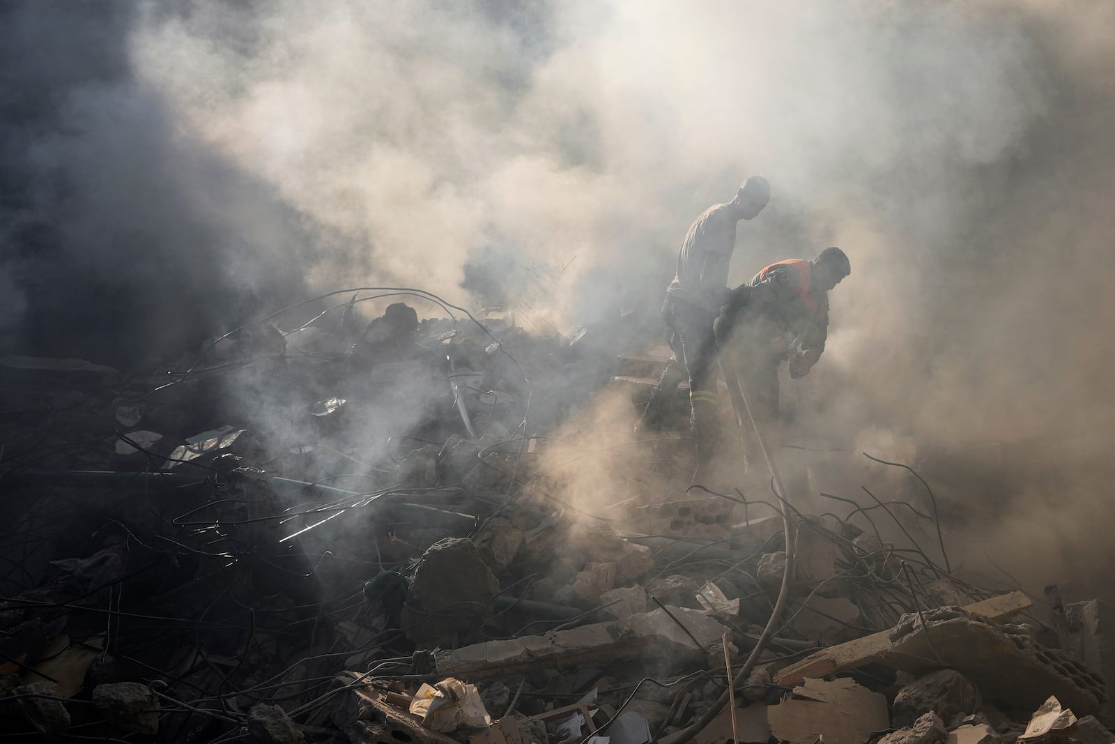 Rescue workers search for victims at the site of Thursday's Israeli airstrike in Beirut, Lebanon, Friday, Oct. 11, 2024. (AP Photo/Hassan Ammar)