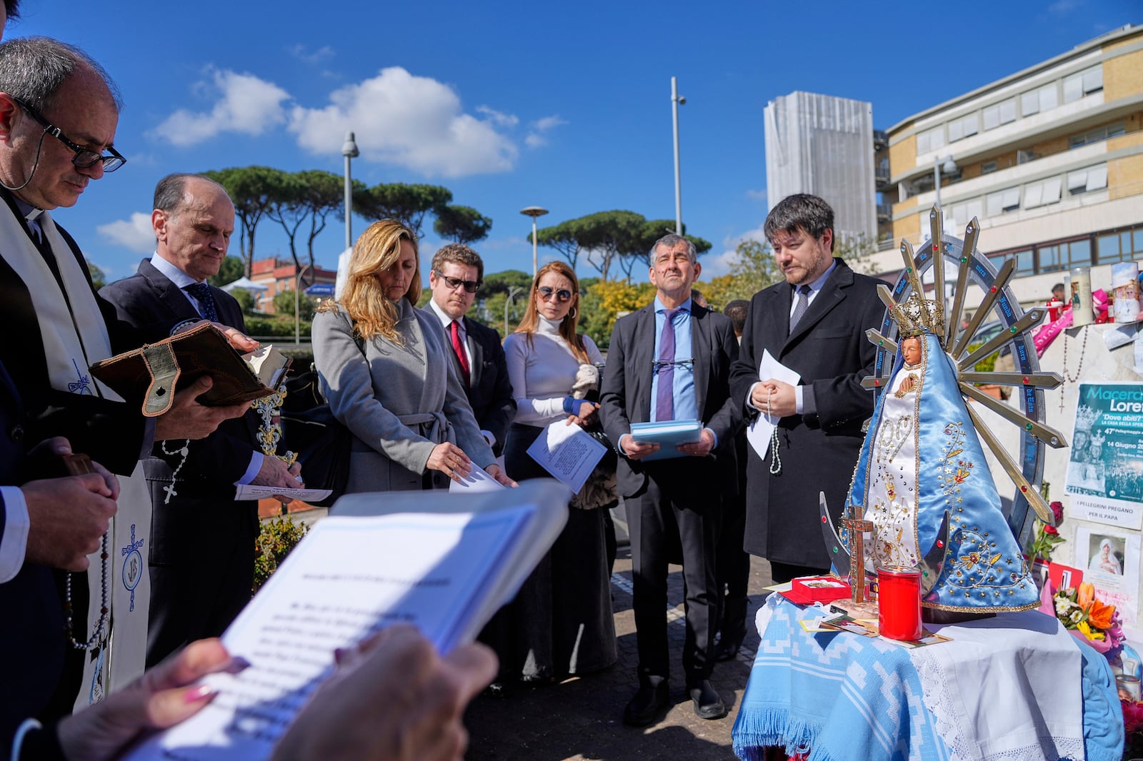 Argentinian Ambassador to the Holy See Luis Pablo Maria Beltramino, second from left, prays with compatriots in front of a statuette of the Virgin of Lujan outside the Agostino Gemelli Polyclinic in Rome, Tuesday, March 4, 2025. (AP Photo/Gregorio Borgia)