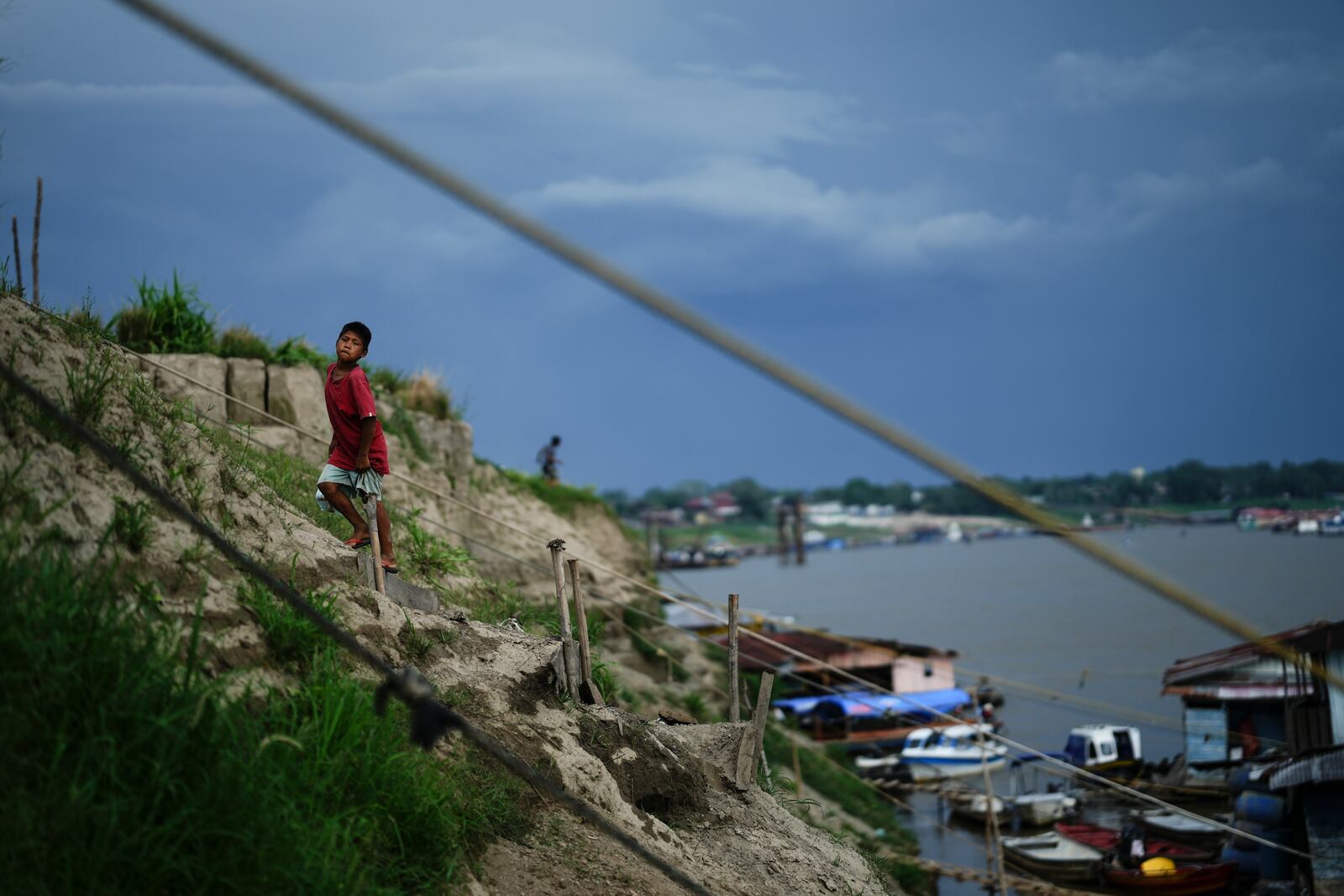 FILE - A boy climbs a hill near a low Amazon River due to the drought, in Leticia, Colombia, Oct. 20, 2024. (AP Photo/Ivan Valencia, File)