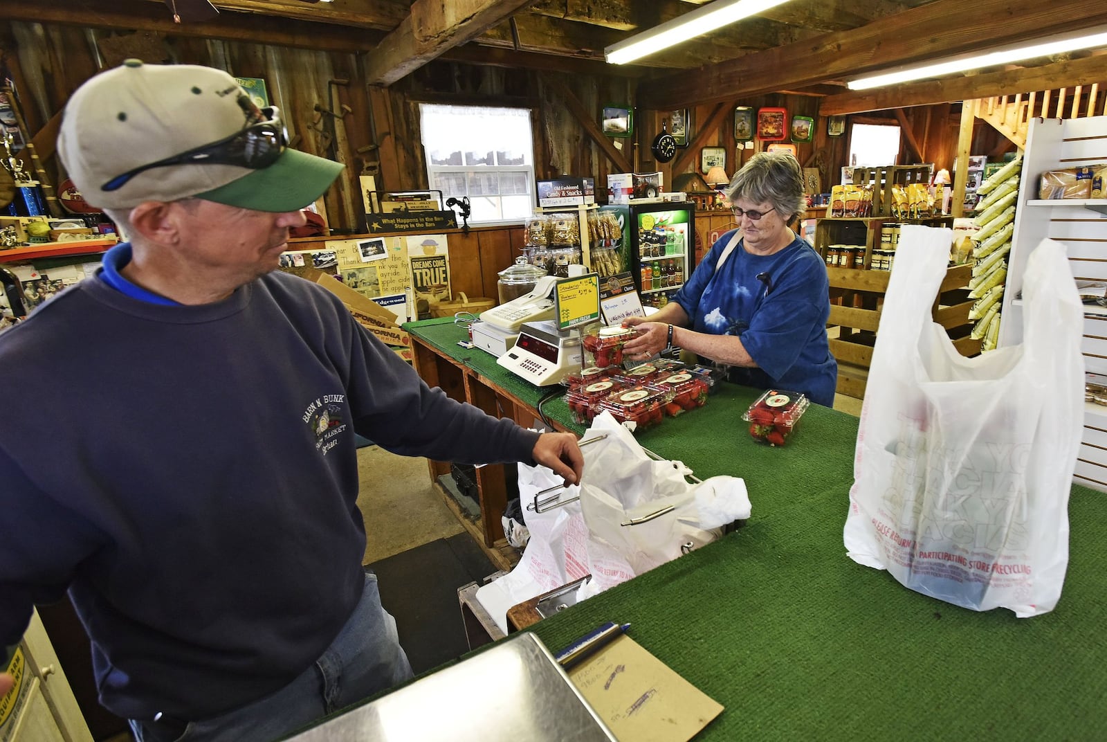 Brian Theobold, with Barn-N-Bunk Farm Market, sells strawberries to Tina Sawyer.