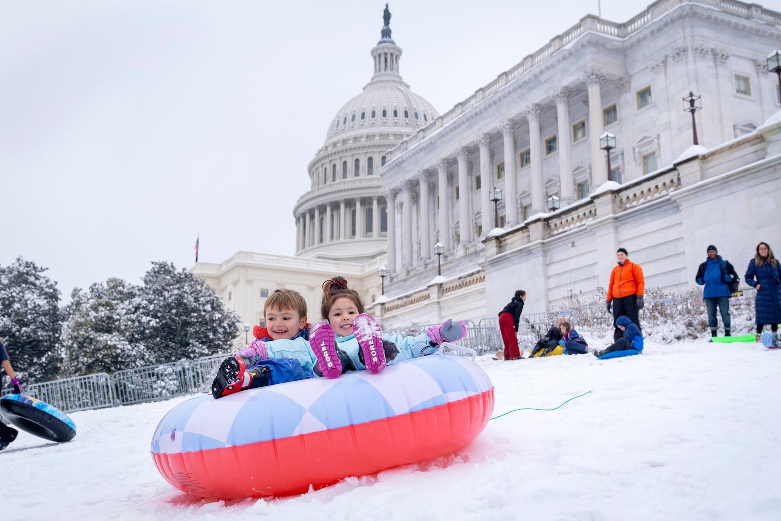 James Prince, 4, and Olivia Averyt, 4, sled down a hill at the Capitol, Wednesday, Feb. 12, 2025, after a snowstorm in Washington. (AP Photo/Jacquelyn Martin)