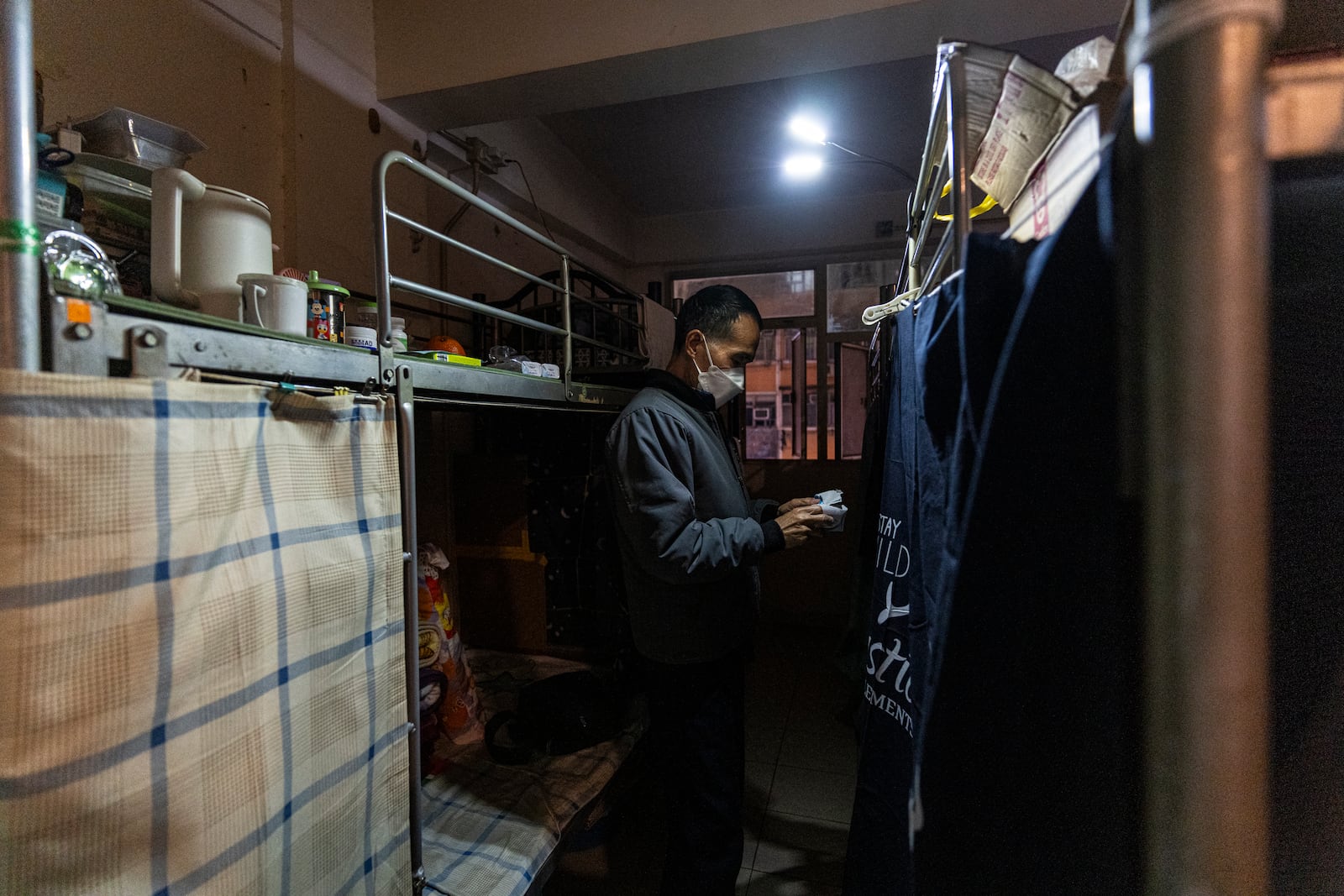 Resident Chung Shing-sun stands near his bed space in Sham Shui Po district of Hong Kong, on Feb. 6, 2025. (AP Photo/Chan Long Hei)