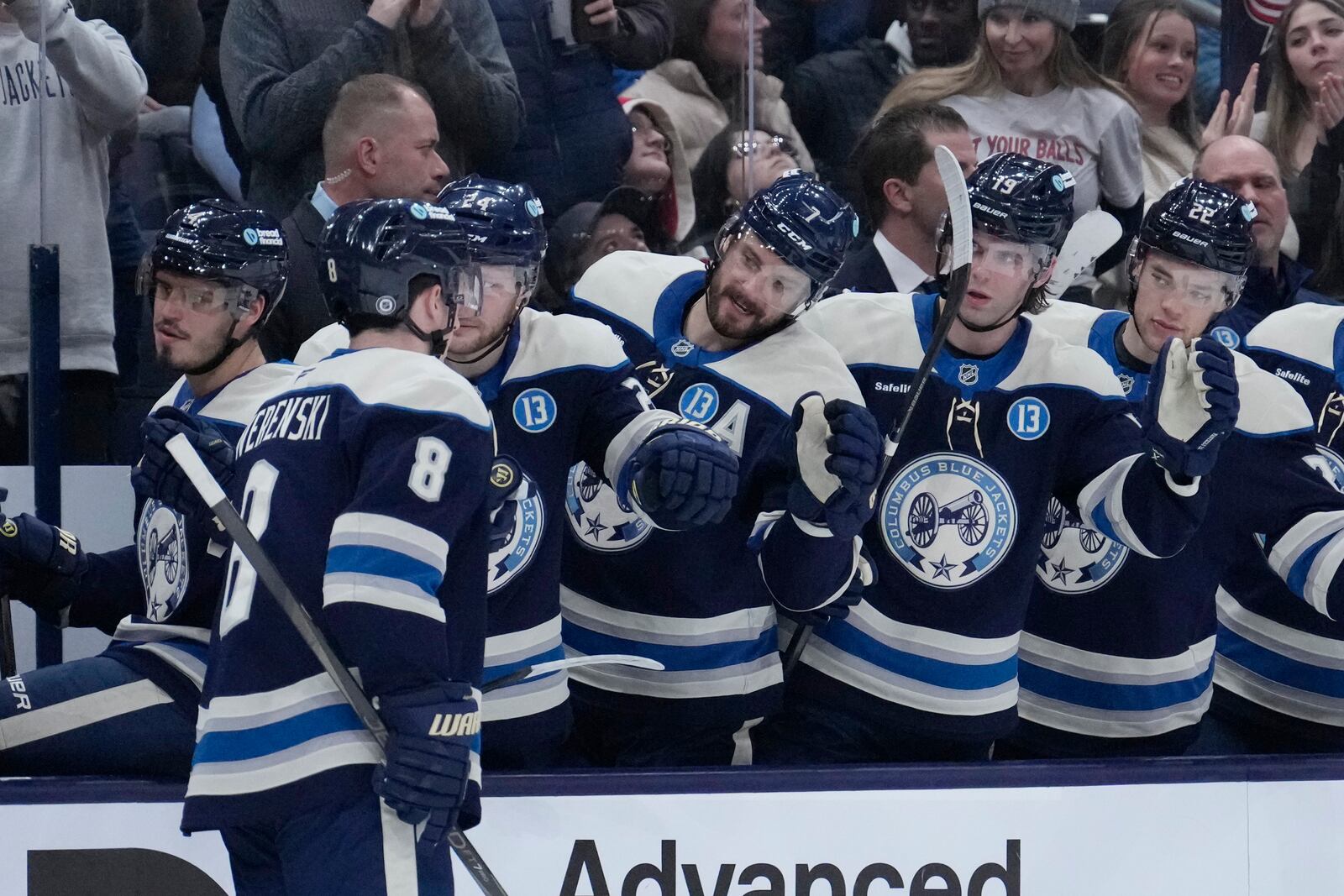 Columbus Blue Jackets defenseman Zach Werenski (8) is congratulated by teammates after scoring in the second period of an NHL hockey game against the New Jersey Devils Thursday, Dec. 19, 2024, in Columbus, Ohio. (AP Photo/Sue Ogrocki)