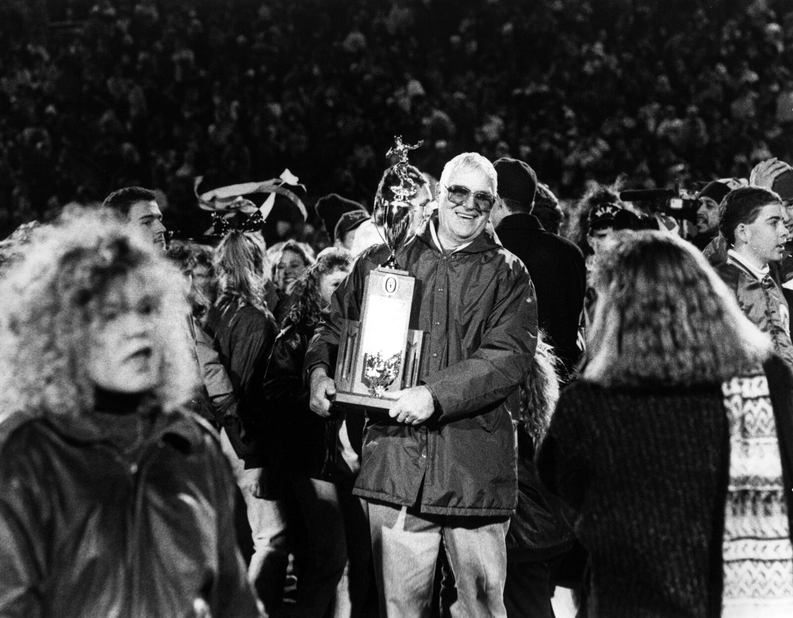 Badin High School football coach Terry Malone happily holds the trophy on Nov. 23, 1990, after the Rams captured the Division III state championship with a 16-6 victory over Richfield Revere at Paul Brown Tiger Stadium in Massillon. JOURNAL-NEWS FILE PHOTO