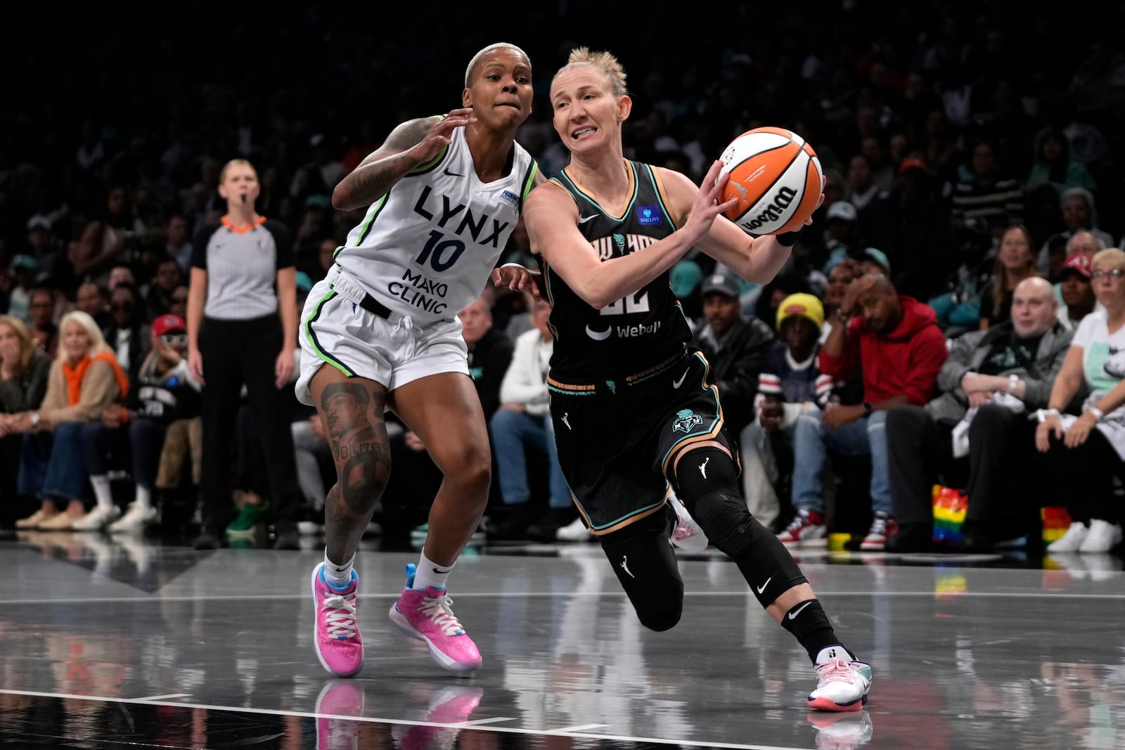 New York Liberty's Courtney Vandersloot, right, drives for the basket against Minnesota Lynx's Courtney Williams, left, during the first half in Game 1 of a WNBA basketball final playoff series, Thursday, Oct. 10, 2024, in New York. (AP Photo/Pamela Smith)