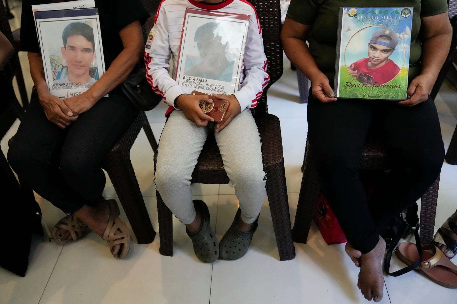 Relatives hold pictures of victims of alleged extra-judicial killings during a press conference a day after the arrest of former Philippine president Rodrigo Duterte in Quezon City, Philippines on Wednesday, March 12, 2025. (AP Photo/Aaron Favila)