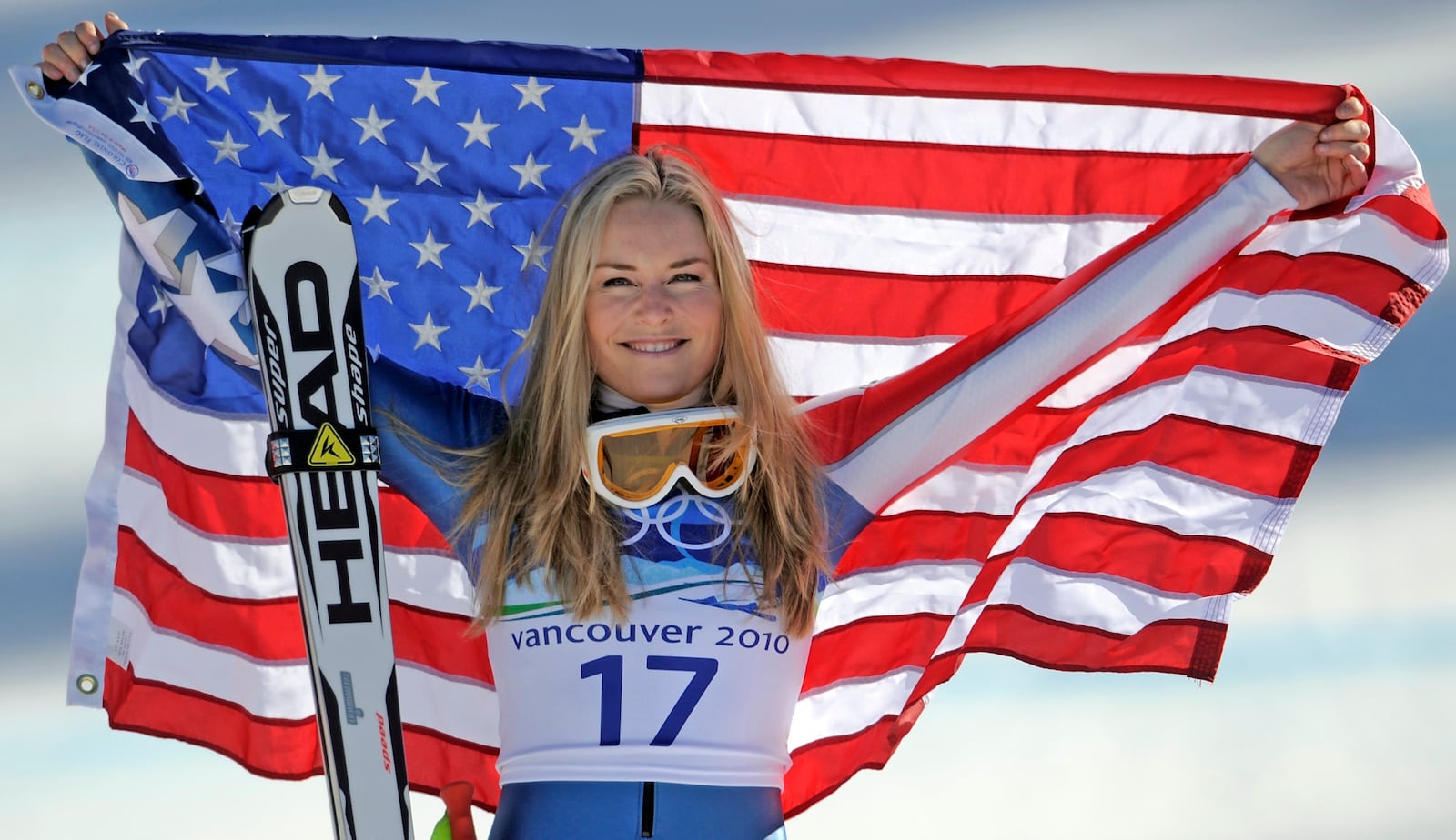 FILE - Bronze medalist Lindsey Vonn of the United States hold the Stars and Stripes during the flower ceremony for the Women's super-G at the Vancouver 2010 Olympics in Whistler, British Columbia, Feb. 20, 2010. (AP Photo/Gero Breloer, File)