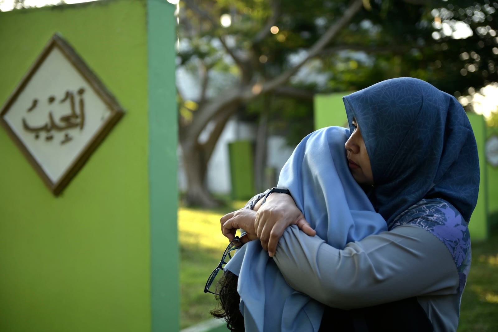 Women comfort each other as they visit a mass grave of victims of the 2004 Indian Ocean tsunami during the commemoration of the 20th year since the disaster, in Banda Aceh, Indonesia, Thursday, Dec. 26, 2024. (AP Photo/Reza Saifullah)