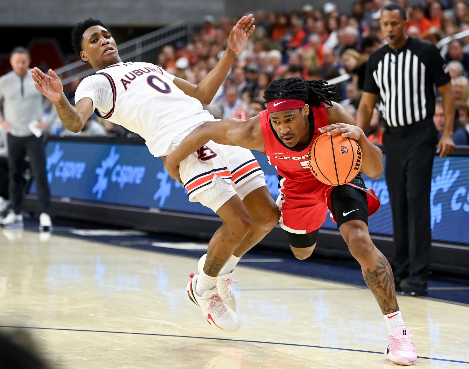 Georgia guard Silas Demary (5) drives past Auburn guard Tahaad Pettiford (0) during the first half an NCAA college basketball game Saturday, Feb. 22, 2025, in Auburn, Ala. (AP Photo/Julie Bennett)