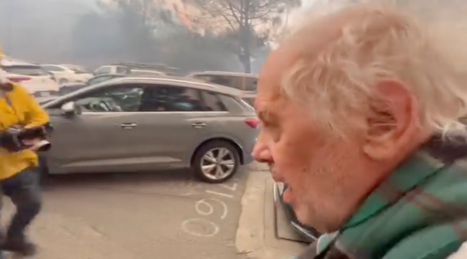 This image taken from video provided by Aaron Samson shows his 83-year-old father-in-law escaping the wildfires after they evacuated a vehicle near Glenhaven, Calif., on Tuesday, Jan. 7, 2025. (Aaron Samson via AP)