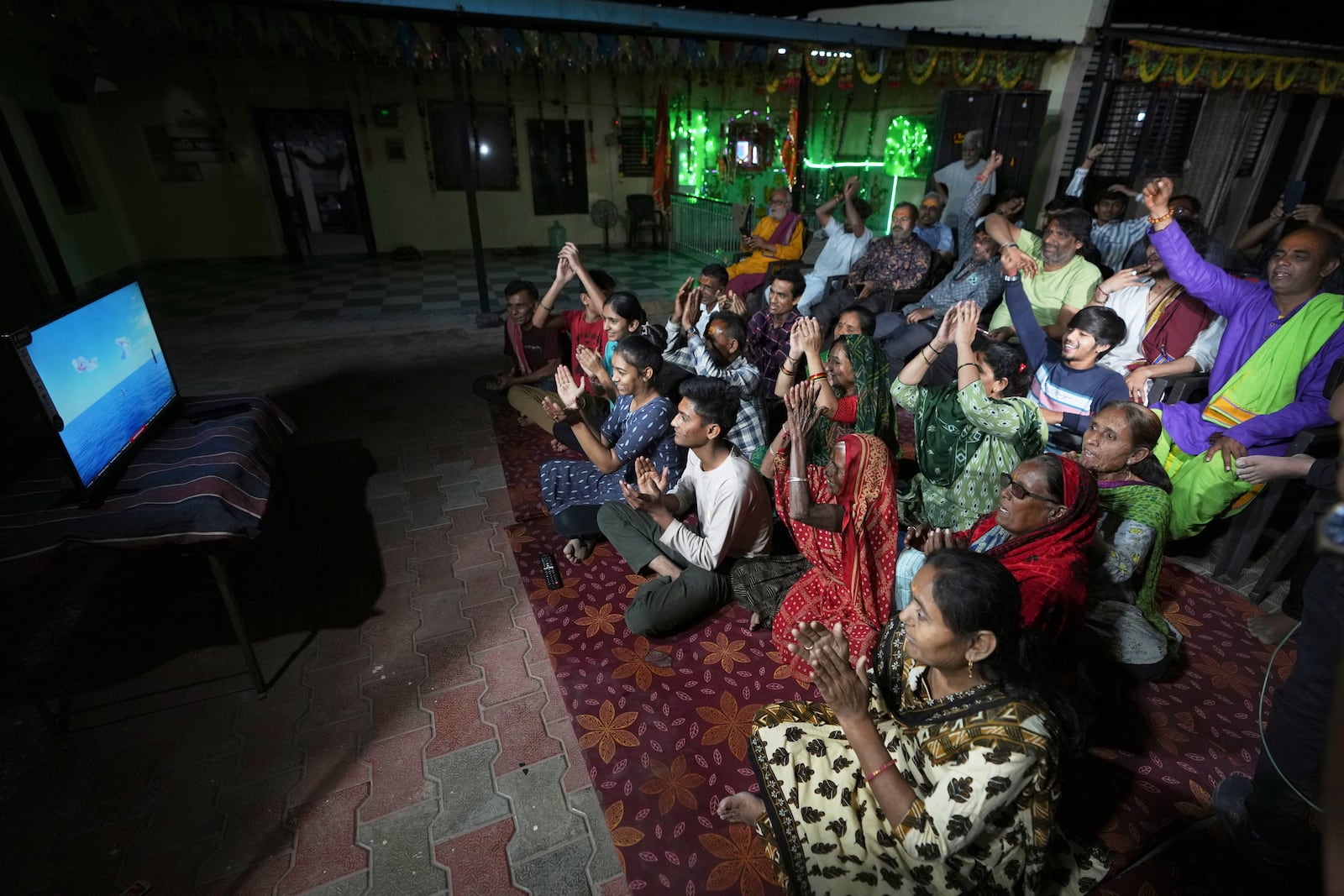 Villagers cheer while watching a NASA live stream as they gather to pray for the safe return of NASA astronaut Suni Williams from the International Space Station (ISS), at a temple in her ancestral village Jhulasan in Mehsana district of Gujarat state, India, Wednesday, March 19, 2025. (AP Photo/Ajit Solanki)