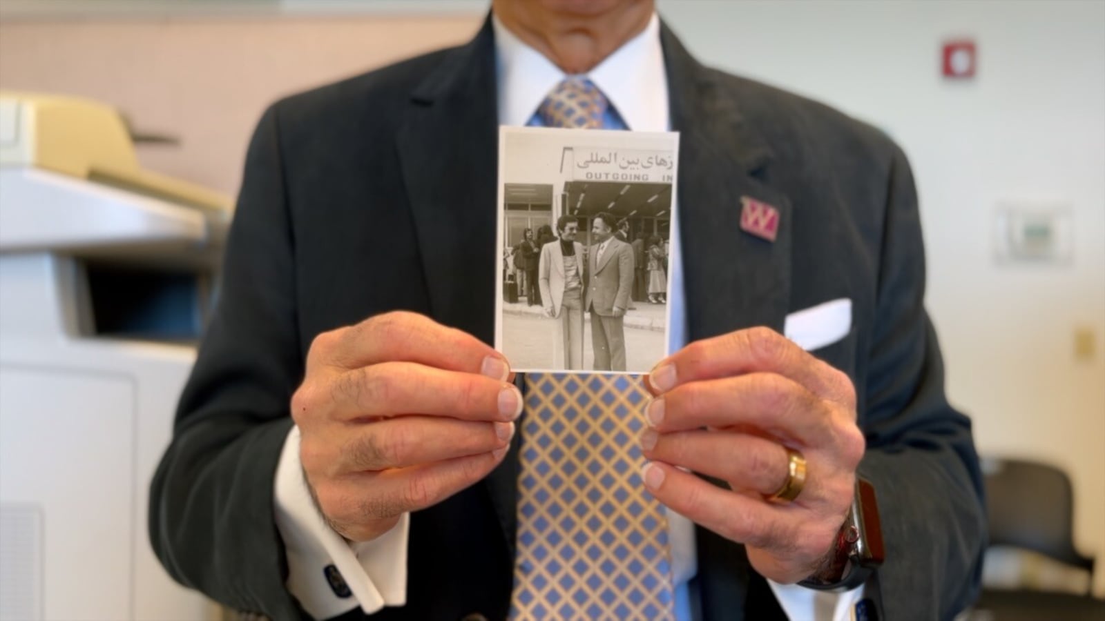 George Sehi holds up a picture from the airport when he left Iran to come to  America in 1975. He says he had nothing but $500 in his pocket, and he uses this experience with his nonprofit, Women Walking West. KEITH BIERYGOLICK/WCPO