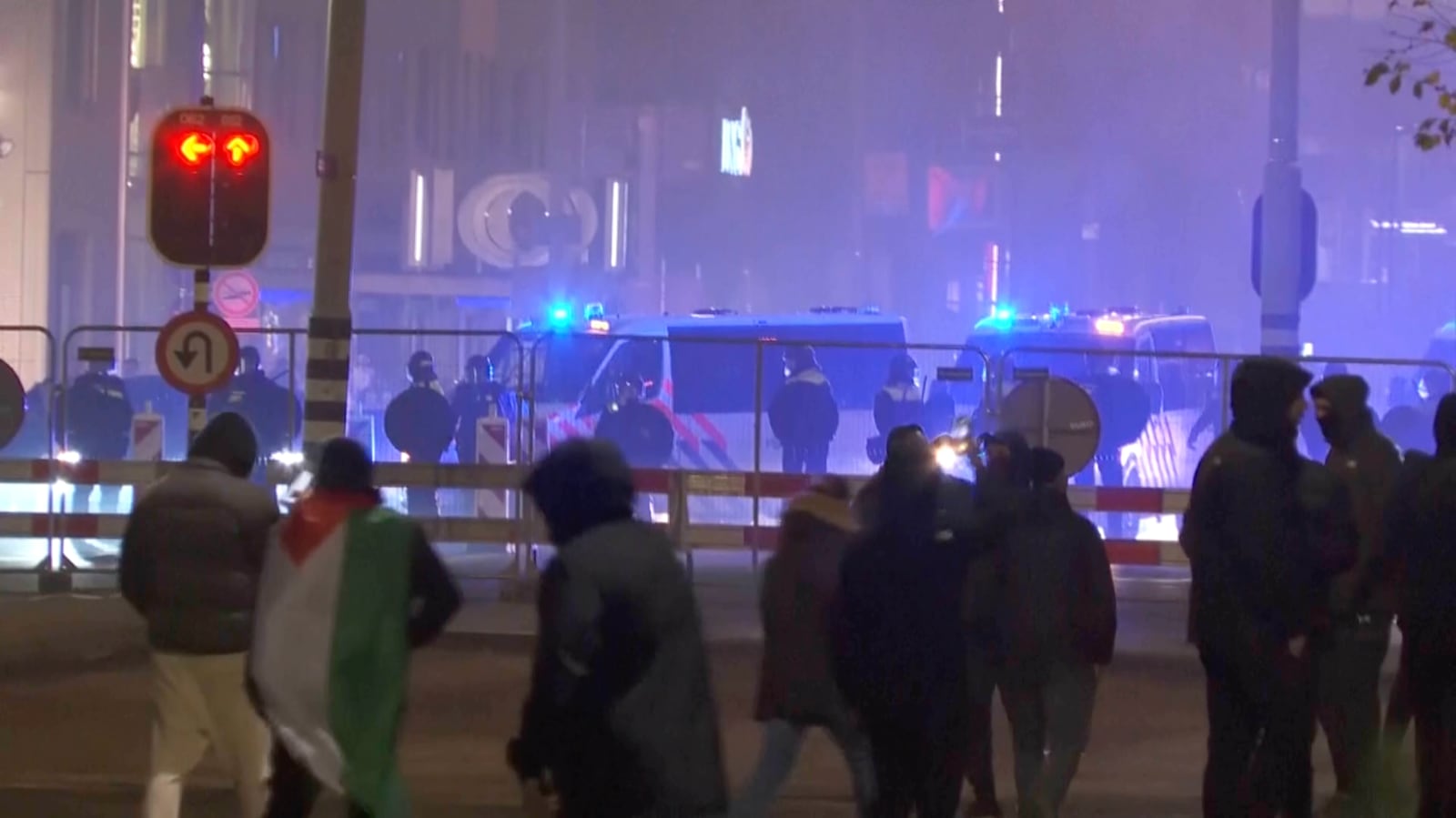 In this image taken from video, a group of pro-Palestinian protesters walk toward police line, with police vans driving in the background, near the soccer stadium in Amsterdam, Netherlands, Thursday, Nov. 7, 2024. (RTL Nieuws via AP)