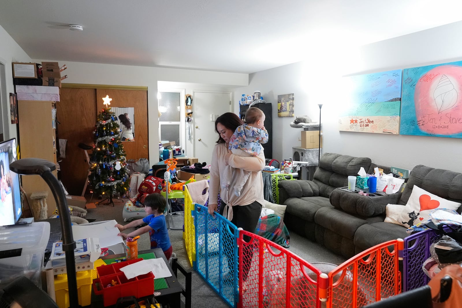 Jennifer Petersen, center, walks with her daughter Carolynn as her son, Jerrick, watches television at their apartment in Campbell, Calif., Wednesday, Jan. 15, 2025. (AP Photo/Godofredo A. Vásquez)