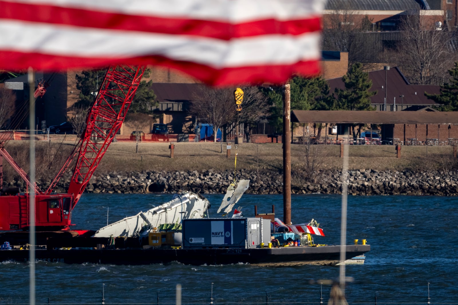 A piece of wreckage is lifted from the water onto a salvage vessel, near the site in the Potomac River of a mid-air collision between an American Airlines jet and a Black Hawk helicopter, at Ronald Reagan Washington National Airport, Tuesday, Feb. 4, 2025, in Arlington, Va. (AP Photo/Ben Curtis)