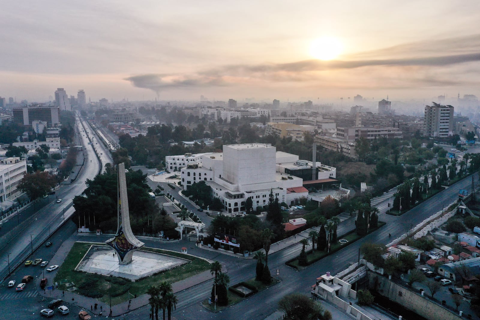 An aerial view shows a column of black smoke in the background, allegedly caused by an Israeli airstrike, as seen from Umayyad square in Damascus, Syria, Tuesday, Dec. 10, 2024.(AP Photo/Ghaith Alsayed)