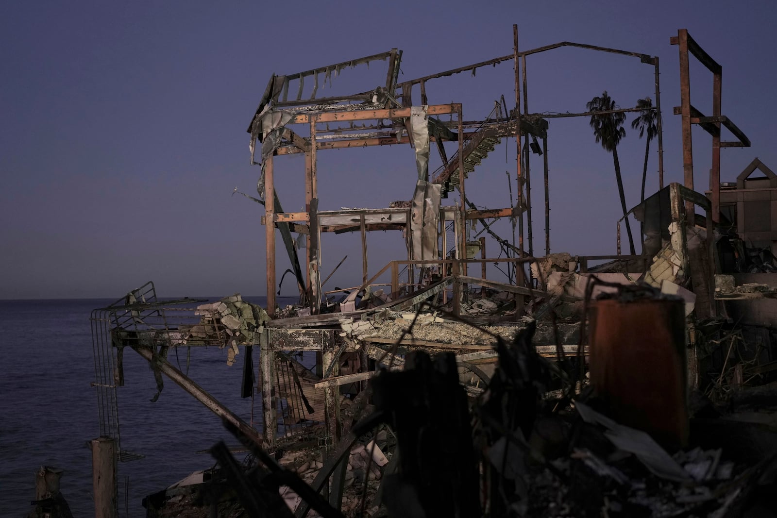 The sun rises behind a burned out home in Malibu, Calif., Tuesday, Jan. 14, 2025. (AP Photo/Carolyn Kaster)