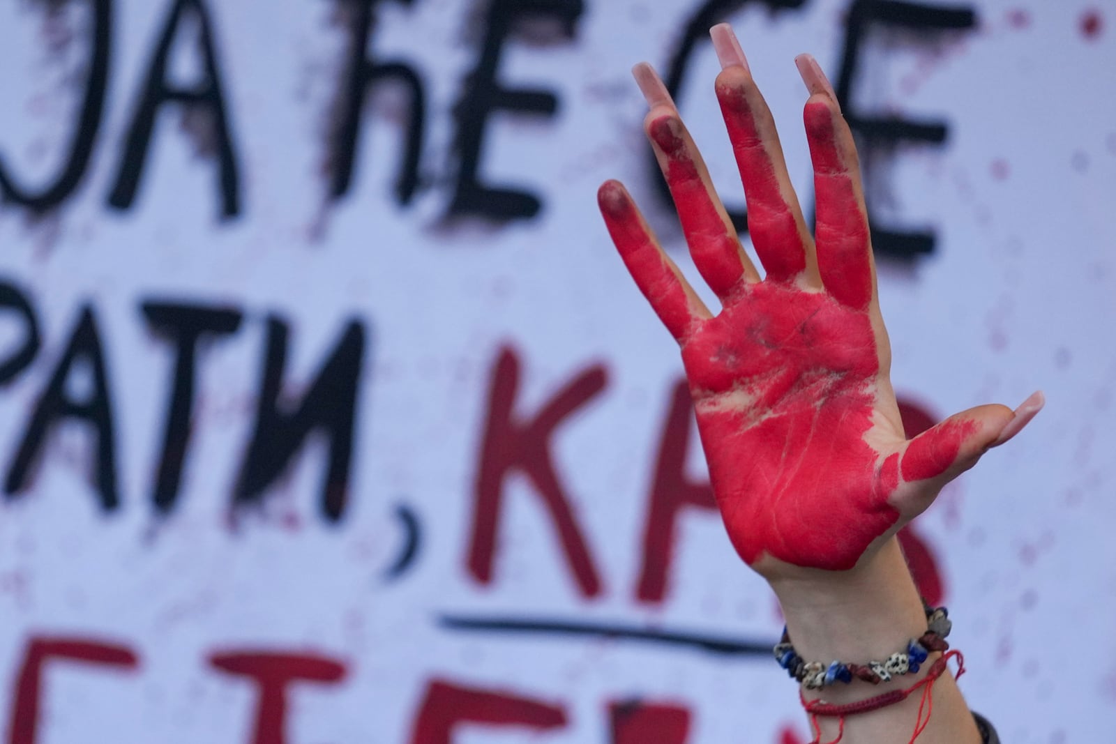 A woman raises a painted hand symbolising the blood, during a protest a day after the assault on students was carried out by thugs with baseball bats, in Novi Sad, Serbia, Tuesday, Jan. 28, 2025. (AP Photo/Darko Vojinovic)