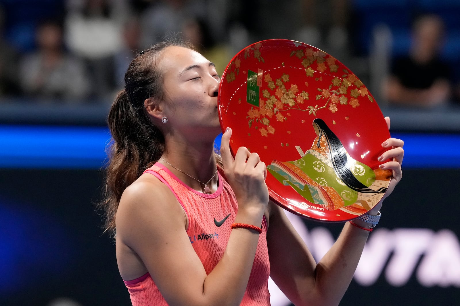 China's Zheng Qinwen kisses her trophy after winning the Pan Pacific Open women's tennis tournament at Ariake Coliseum, in Tokyo, Sunday, Oct. 27, 2024. (AP Photo/Eugene Hoshiko)