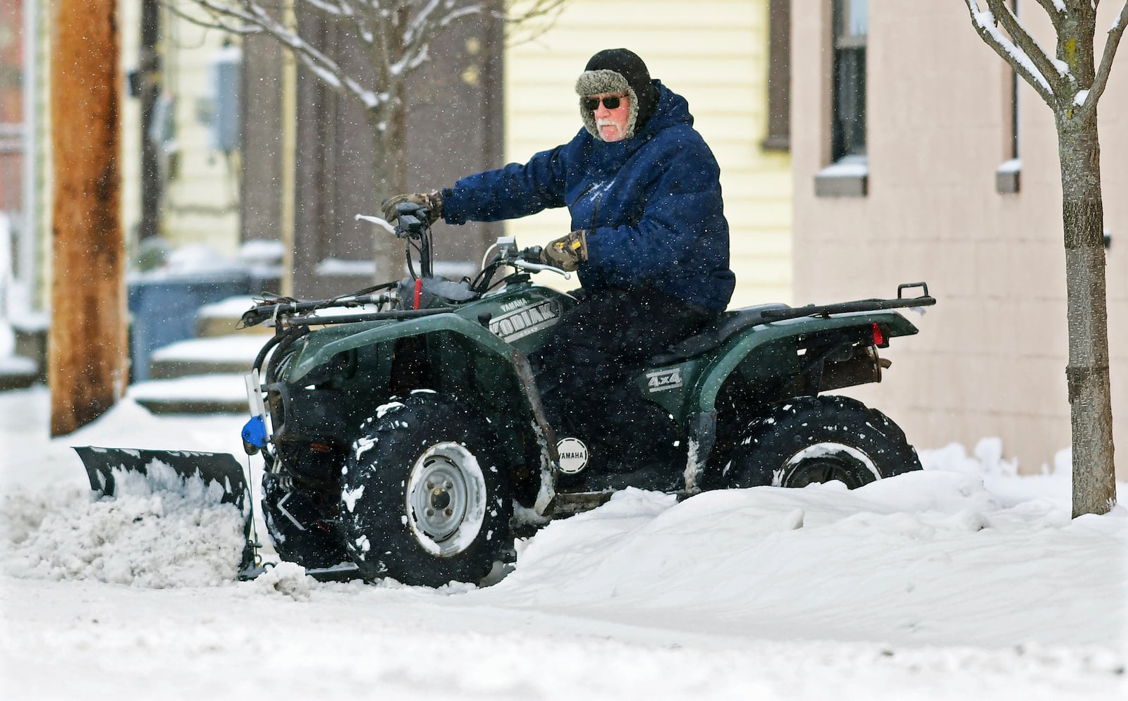 John Lovrich uses his Yamaha Kodiak 450 4x4 all-terrain vehicle to plow snow near his home in the Cambria City section of Johnstown, Pa., Monday, Jan. 6, 2025. (Thomas Slusser/The Tribune-Democrat via AP)