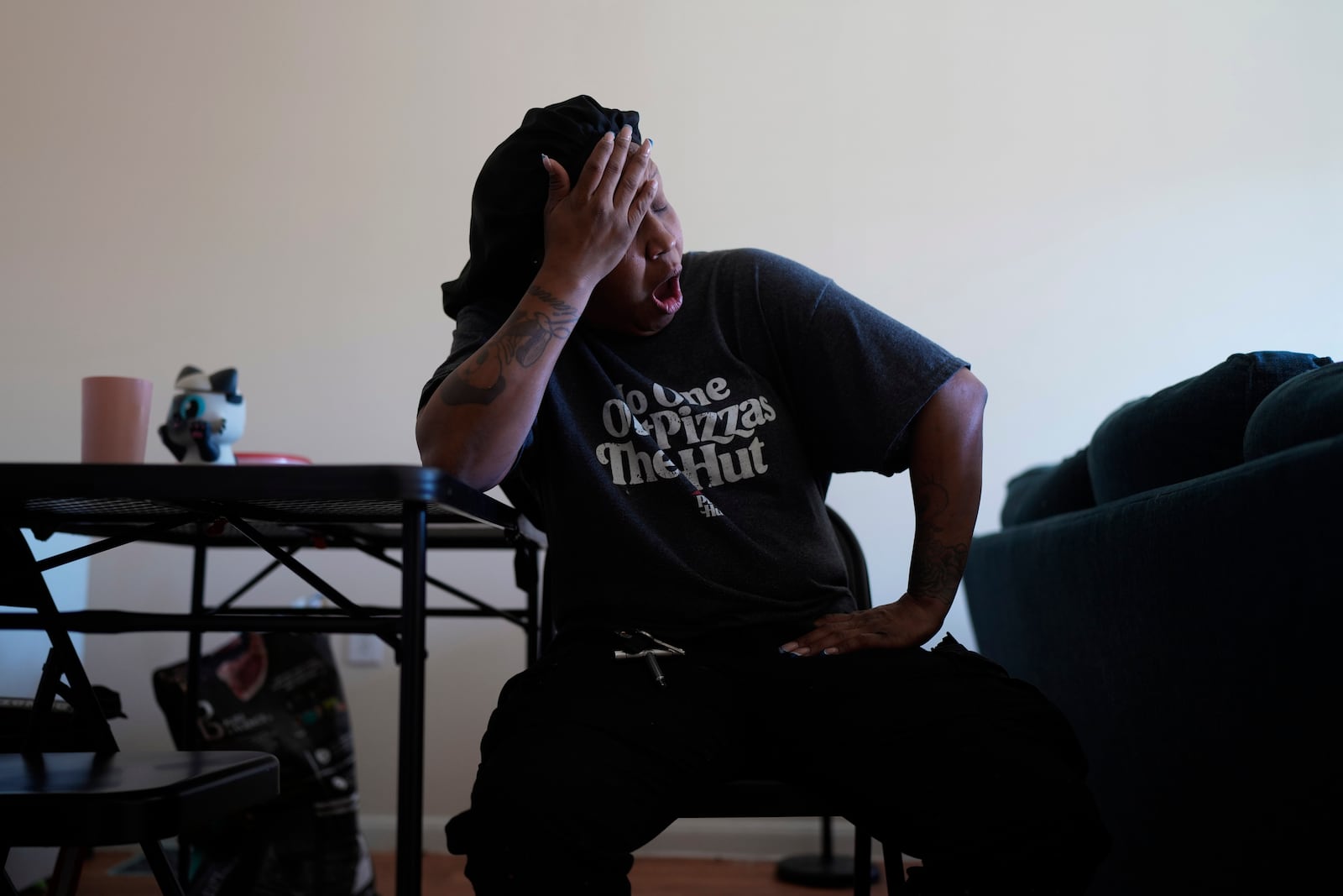 TiAnna Yeldell, a 44-year-old single mom of three, yawns as she prepares for her second job after a short sleep night, Thursday, Nov. 14, 2024, in Missouri City, Texas. (AP Photo/Eric Gay)