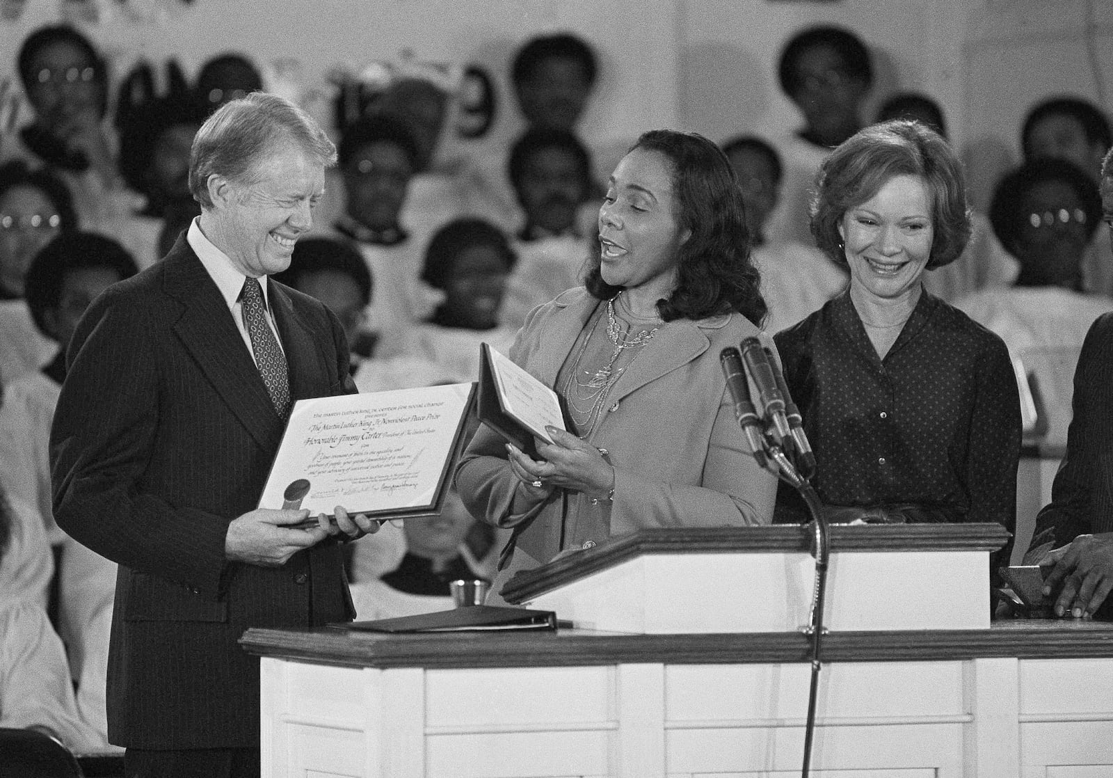 FILE - Coretta Scott King, center, widow of Martin Luther King Jr., presents the Martin Luther King Jr. Nonviolent Peace Prize to President Jimmy Carter at the Ebenezer Baptist Church on Jan. 14, 1979, in Atlanta. First lady Rosalynn Carter stands with them at the podium. (AP Photo/Jim Wells, File)