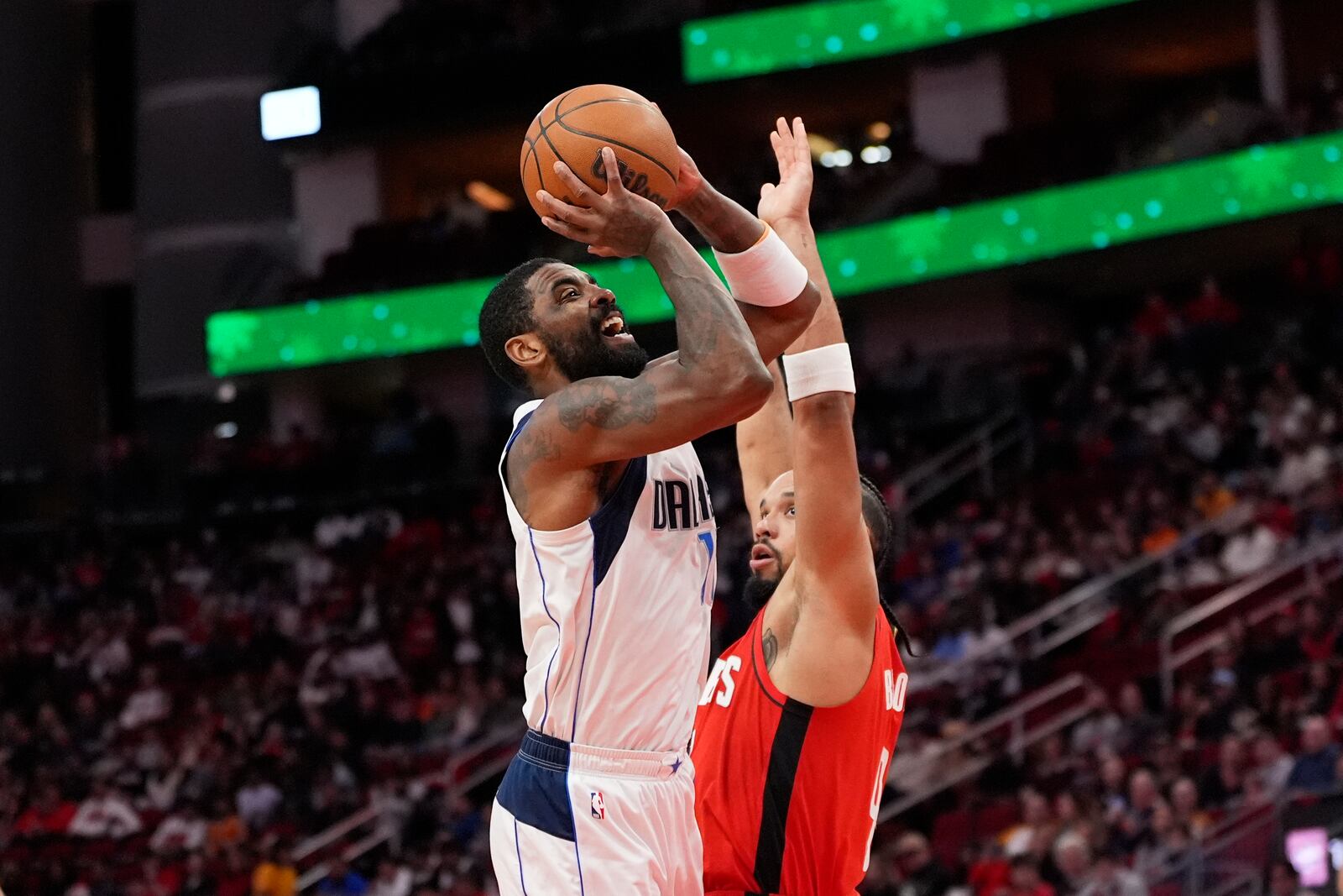 Dallas Mavericks' Kyrie Irving, left, shoots as Houston Rockets' Dillon Brooks defends during the first half of an NBA basketball game Wednesday, Jan. 1, 2025, in Houston. (AP Photo/David J. Phillip)