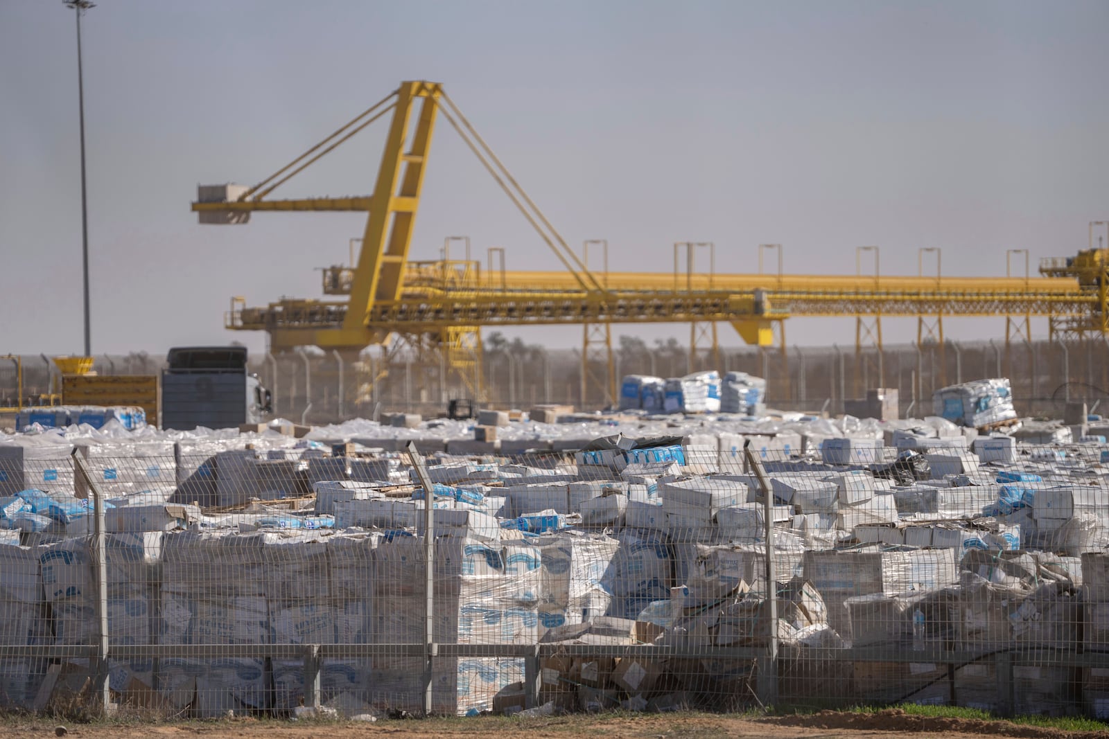 FILE - Humanitarian aid sits, waiting to be picked up on the Palestinian side of the Kerem Shalom aid crossing in the Gaza Strip, on Dec. 19, 2024. (AP Photo/Ohad Zwigenberg, File)