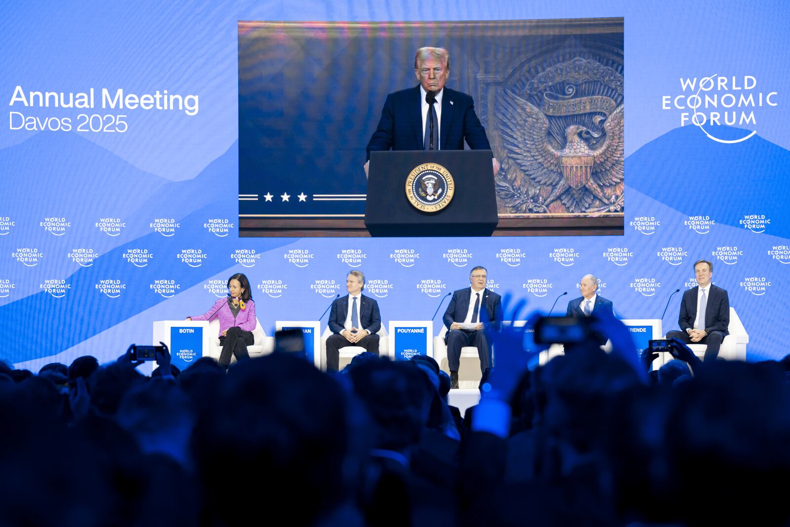 US President Donald J. Trump is shown on screens as he addresses via remote connection a plenary session in the Congress Hall, during the 55th annual meeting of the World Economic Forum (WEF), in Davos, Switzerland, Thursday, Jan. 23, 2025. (Michael Buholzer/Keystone via AP)