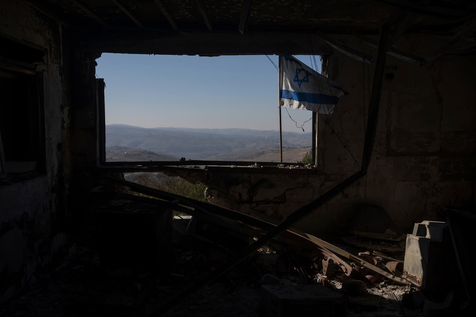 A view of Lebanese village through a window of a damaged house that was hit by a rocket fired from Lebanon, in the Kibbutz Manara, located in the upper Galilee, northern Israel, Monday Dec. 2, 2024. (AP Photo/Ohad Zwigenberg)