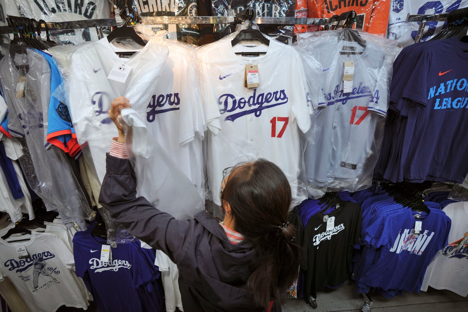 A customer shops around for goods related to Shohei Ohtani of the Los Angeles Dodgers at a sporting goods store, "SELECTION," in Shinjuku district Wednesday, Oct. 23, 2024 in Tokyo. (AP Photo/Eugene Hoshiko)