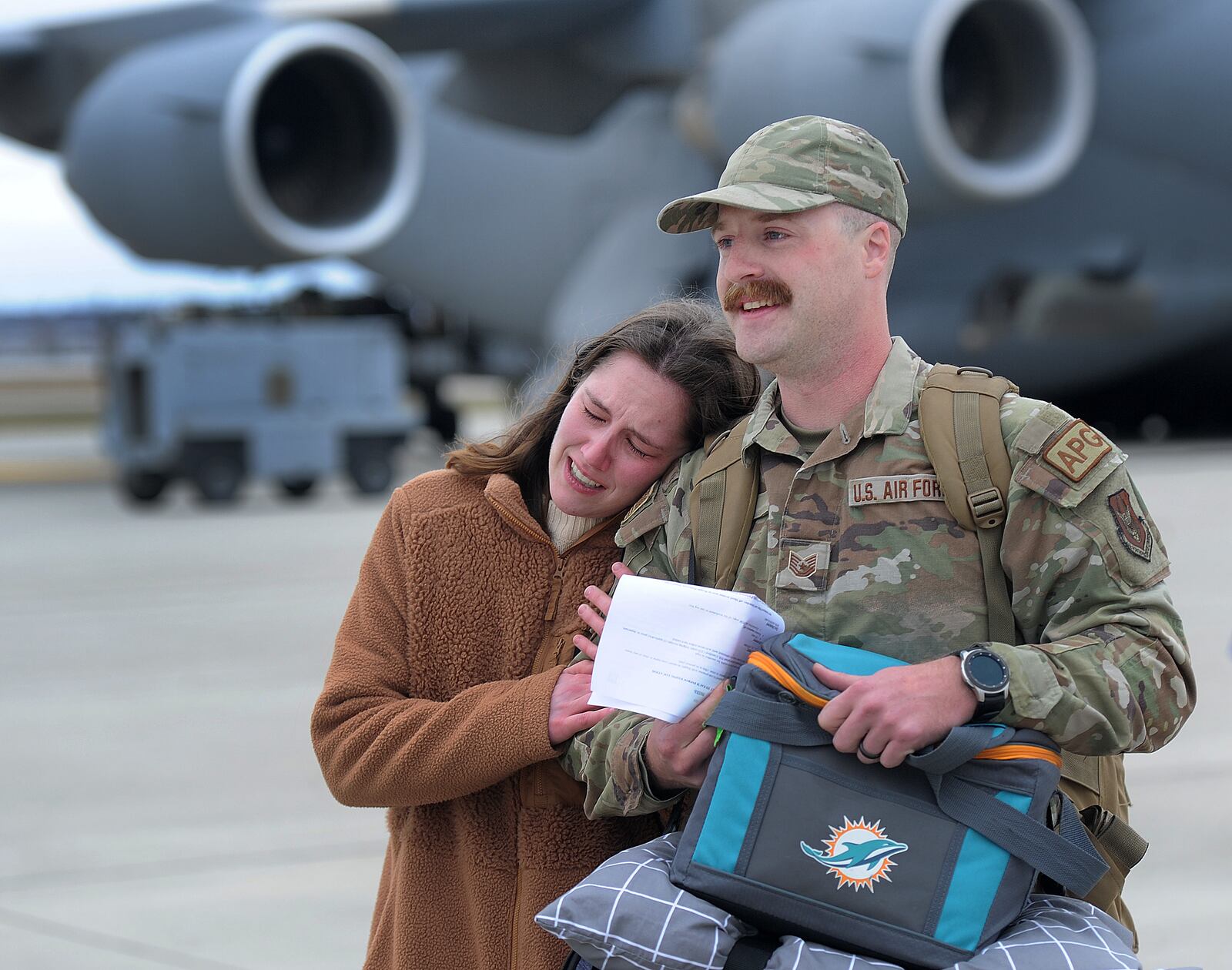 Haley Swift hugs her husband Dustin, Thursday, Jan. 4, 2024 
after he and 140 other airmen arrived home in a quartet of C-17 Globemaster cargo planes, the Airmen returned to Wright-Patterson Air Force Base from more than two months deployed at an undisclosed location. MARSHALL GORBY\STAFF