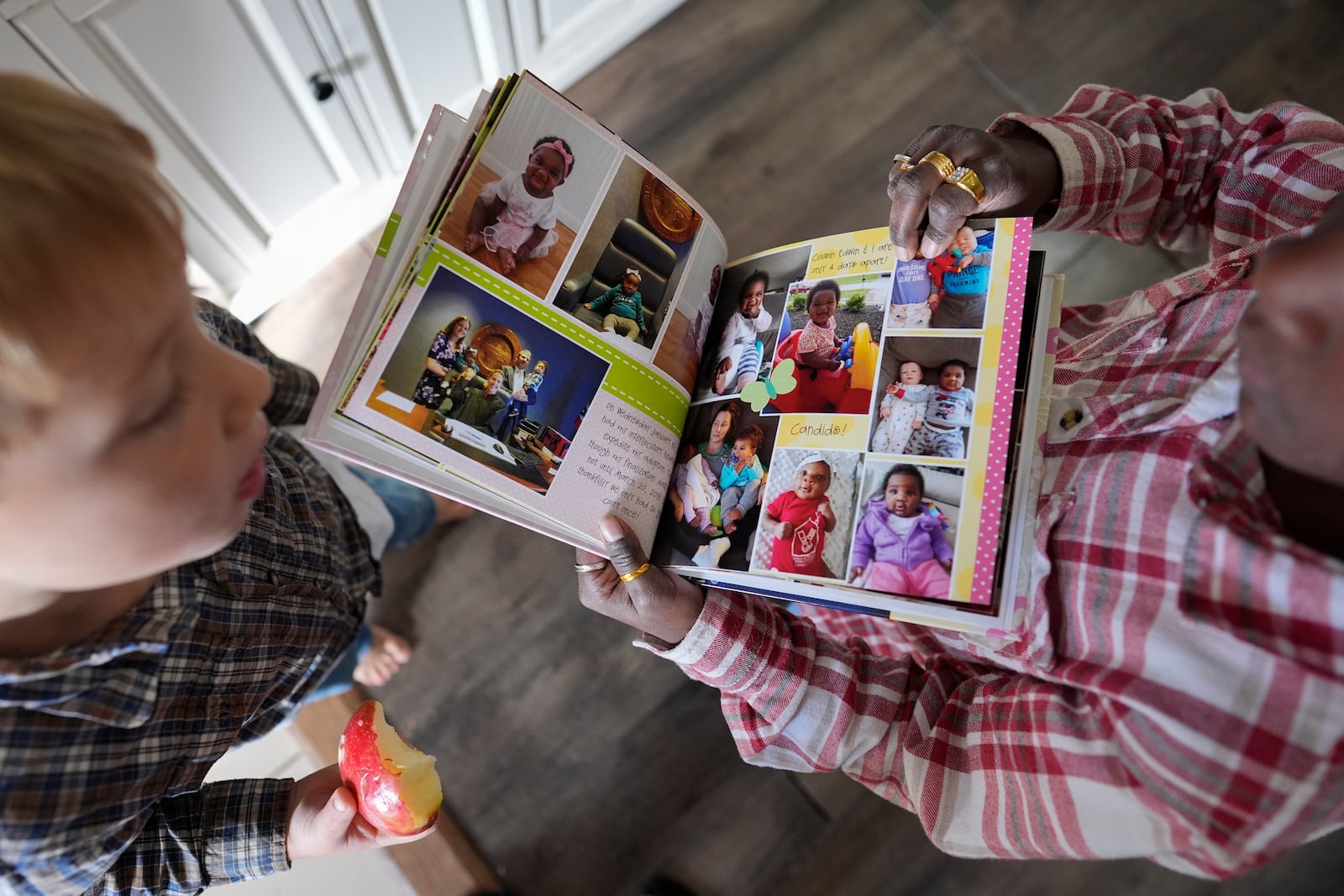 Isaac Young, 5, left, and his big sister Gianna Young, 7, look at her one-year baby book during a homeschool break in their Sunbury, Ohio, home on Tuesday, Nov. 12, 2024. (AP Photo/Carolyn Kaster)