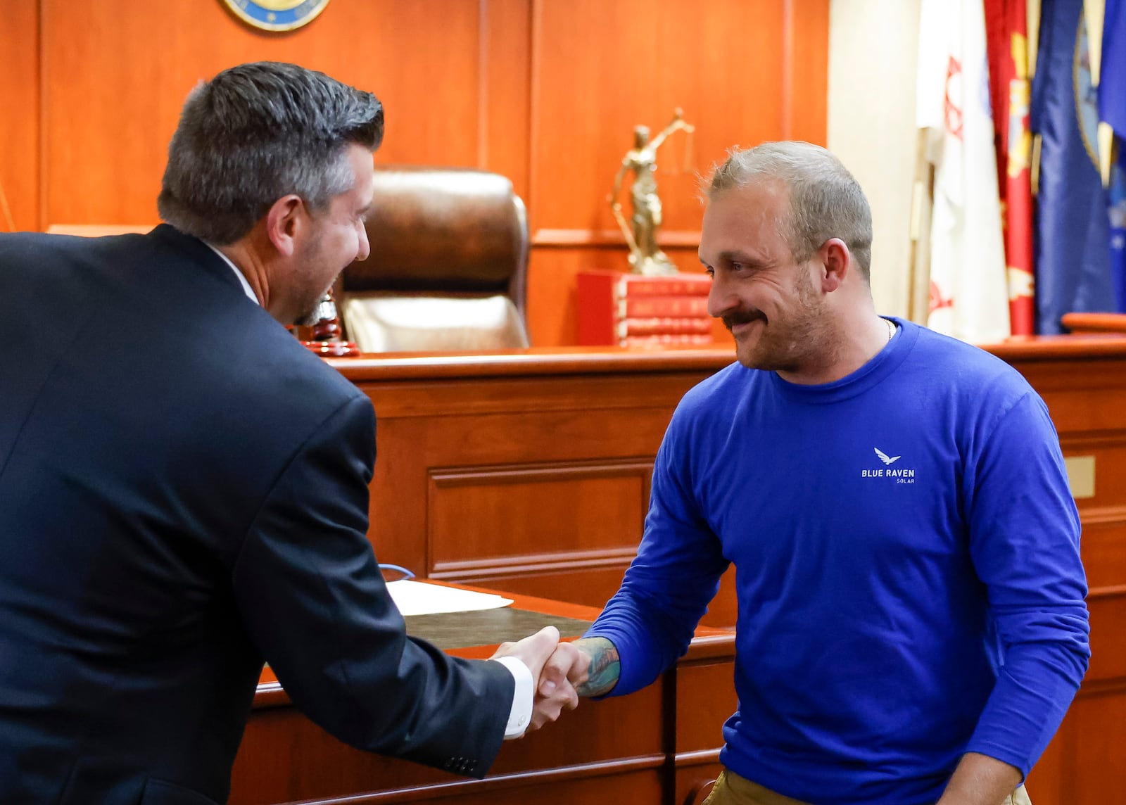 Judge Michael A. Oster Jr., left, signs the final papers for Army veteran Johner Wical, Jr. during Veterans Treatment Court graduation Tuesday, Nov. 15, 2022 in Butler County Common Pleas Court in Hamilton. This class had three graduates for a combined total of 25 graduates since Veterans Treatment Court started in 2017. NICK GRAHAM/STAFF