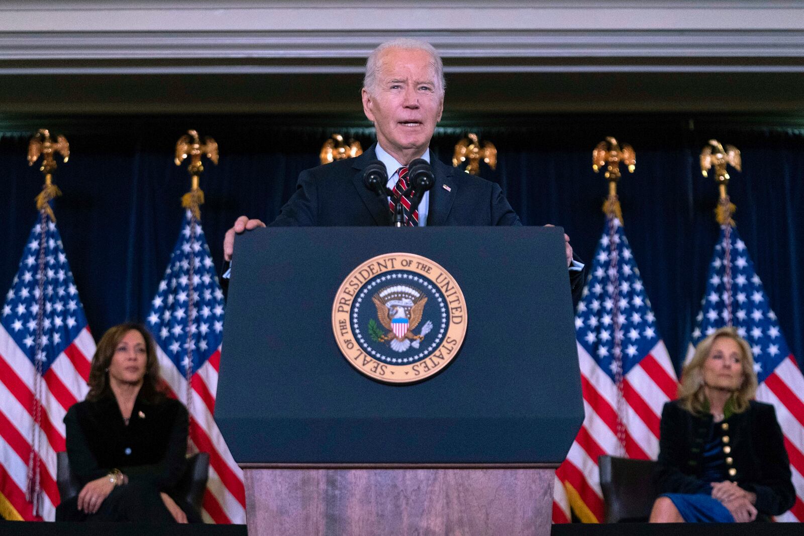 President Joe Biden, accompanied by Vice President Kamala Harris, left, and first lady Jill Biden, right, delivers his remarks at the Democratic National Committee's Holiday Reception at Willard Hotel in Washington, Sunday, Dec. 15, 2024. (AP Photo/Jose Luis Magana)