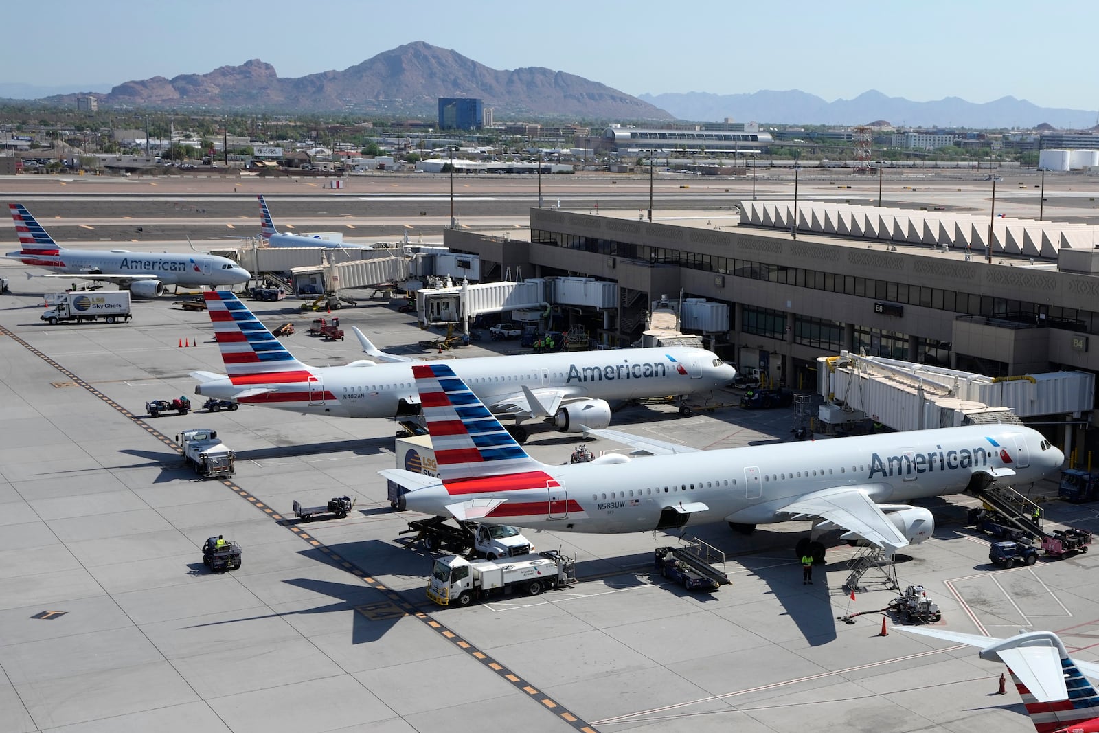 FILE - American Airlines planes wait at gates at Phoenix Sky Harbor International Airport Friday, July 19, 2024, in Phoenix. (AP Photo/Ross D. Franklin, File)