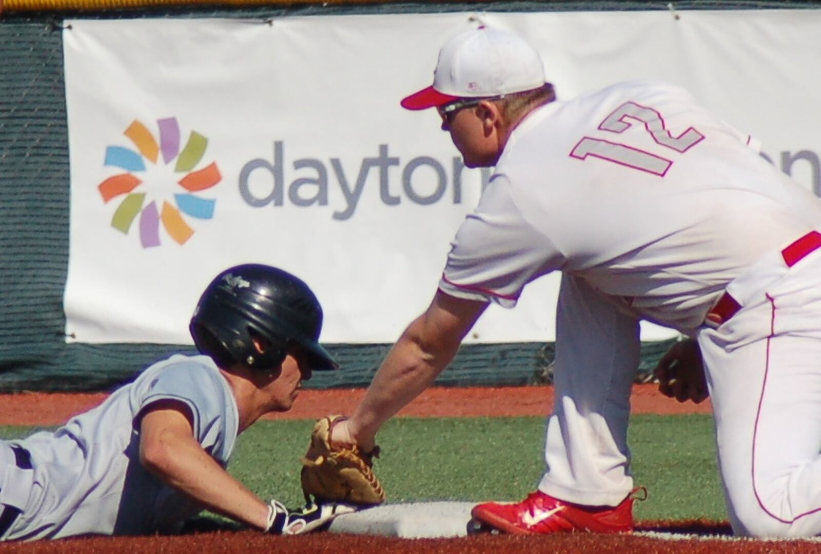 Carlisle first baseman Logan Baker tries to pick off a Cincinnati Hills Christian Academy runner Friday during a Division III regional final at the Athletes in Action complex in Xenia. CONTRIBUTED PHOTO BY JOHN CUMMINGS