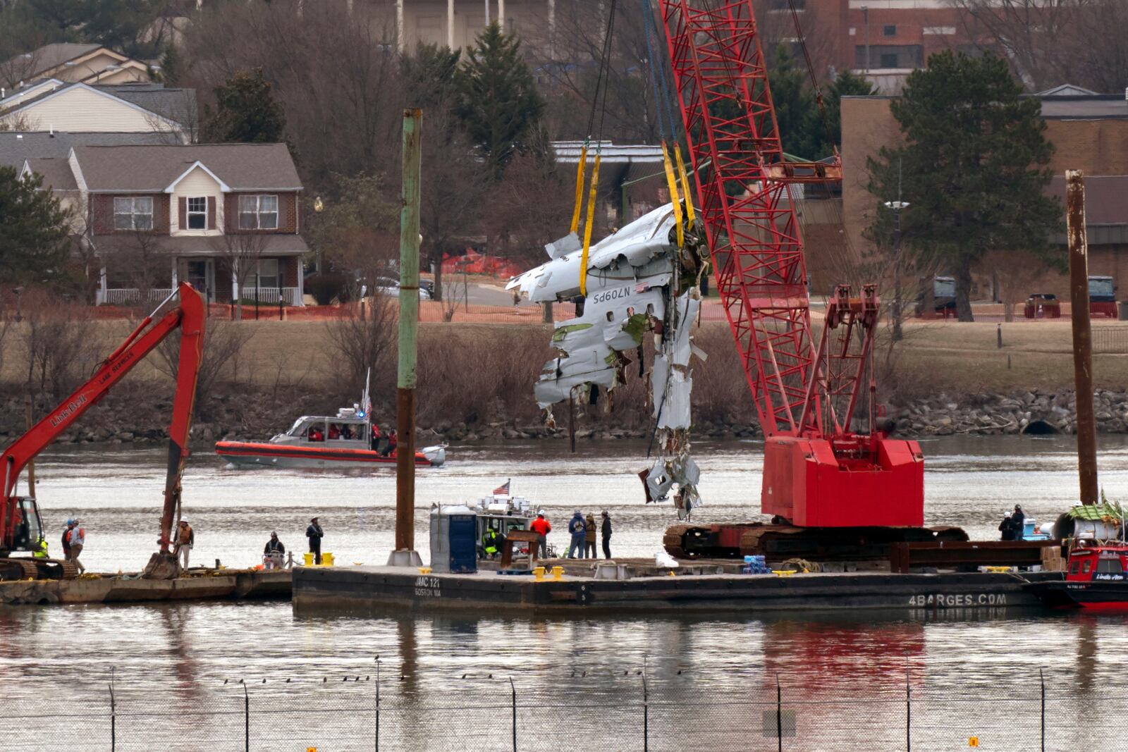 Rescue and salvage crews with cranes pull up the wreckage of an American Airlines jet in the Potomac River from Ronald Reagan Washington National Airport, Monday, Feb. 3, 2025, in Arlington, Va. (AP Photo/Jose Luis Magana)