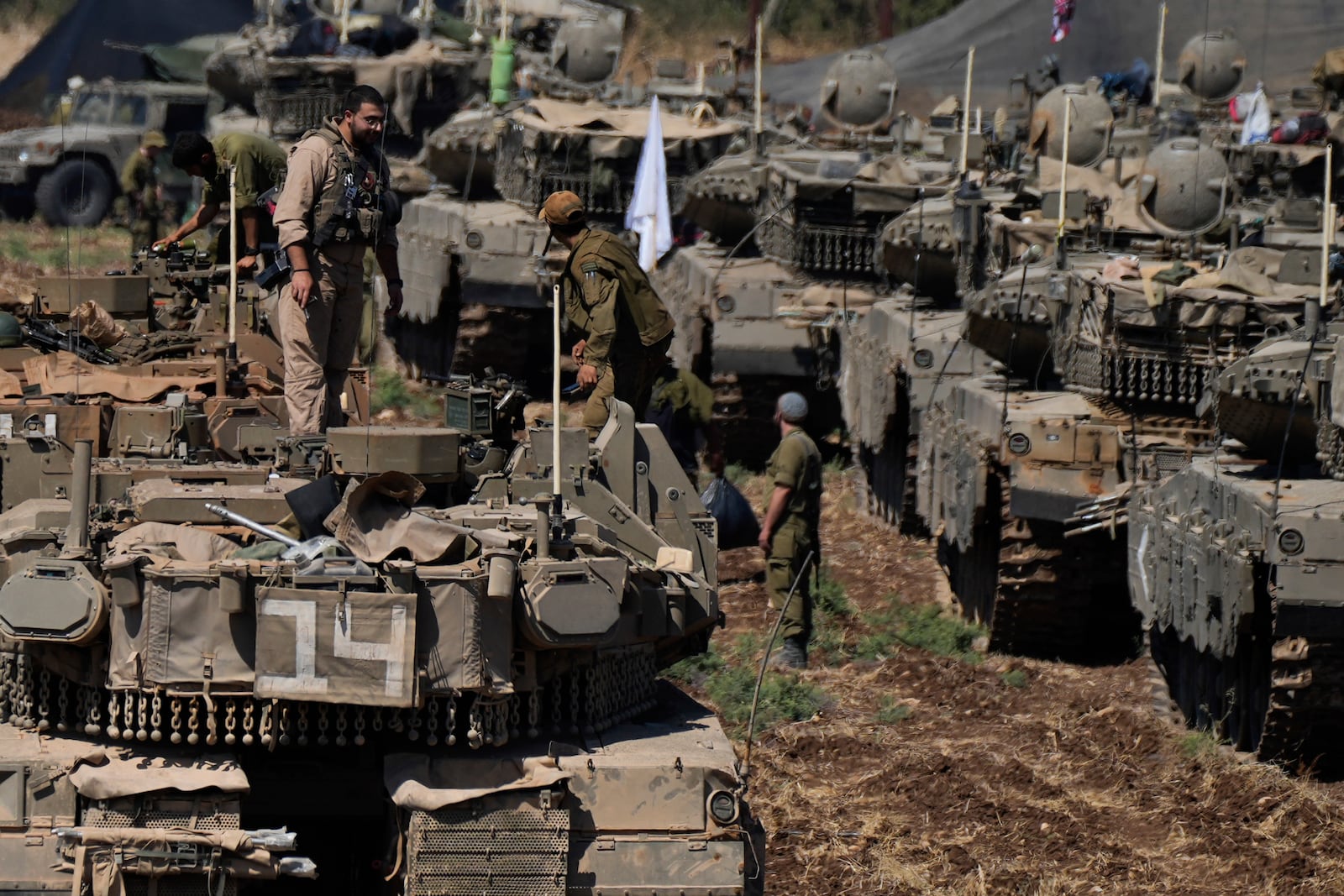 FILE - Israeli soldiers work on tanks in northern Israel on Sept. 27, 2024. (AP Photo/Baz Ratner, File)