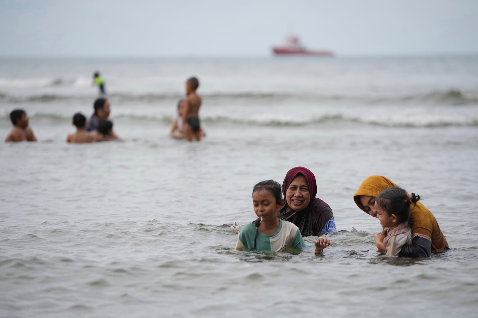 People play in the water at Ulee Lheue beach which was one of the areas hardest hit by Indian Ocean tsunami in 2004, in Banda Aceh, Aceh Province, Indonesia, Friday, Dec. 13, 2024. (AP Photo/Achmad Ibrahim)