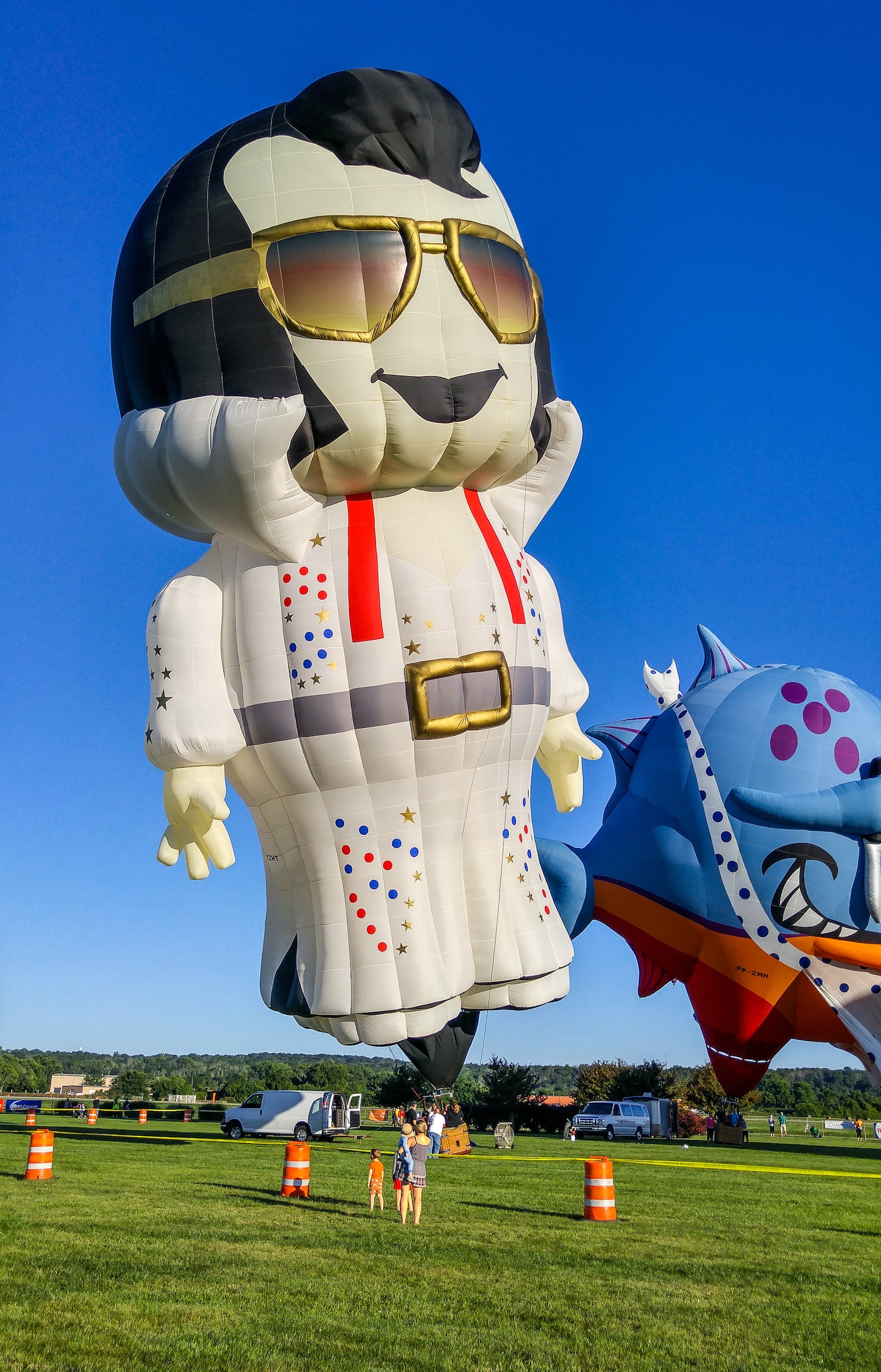 The special-shaped piranha balloon from Brazil and Elvis balloon were inflated for attendees to get a closer look Saturday morning during the Ohio Challenge Hot Air Balloon Festival at Smith Park in Middletown.  NICK GRAHAM/STAFF