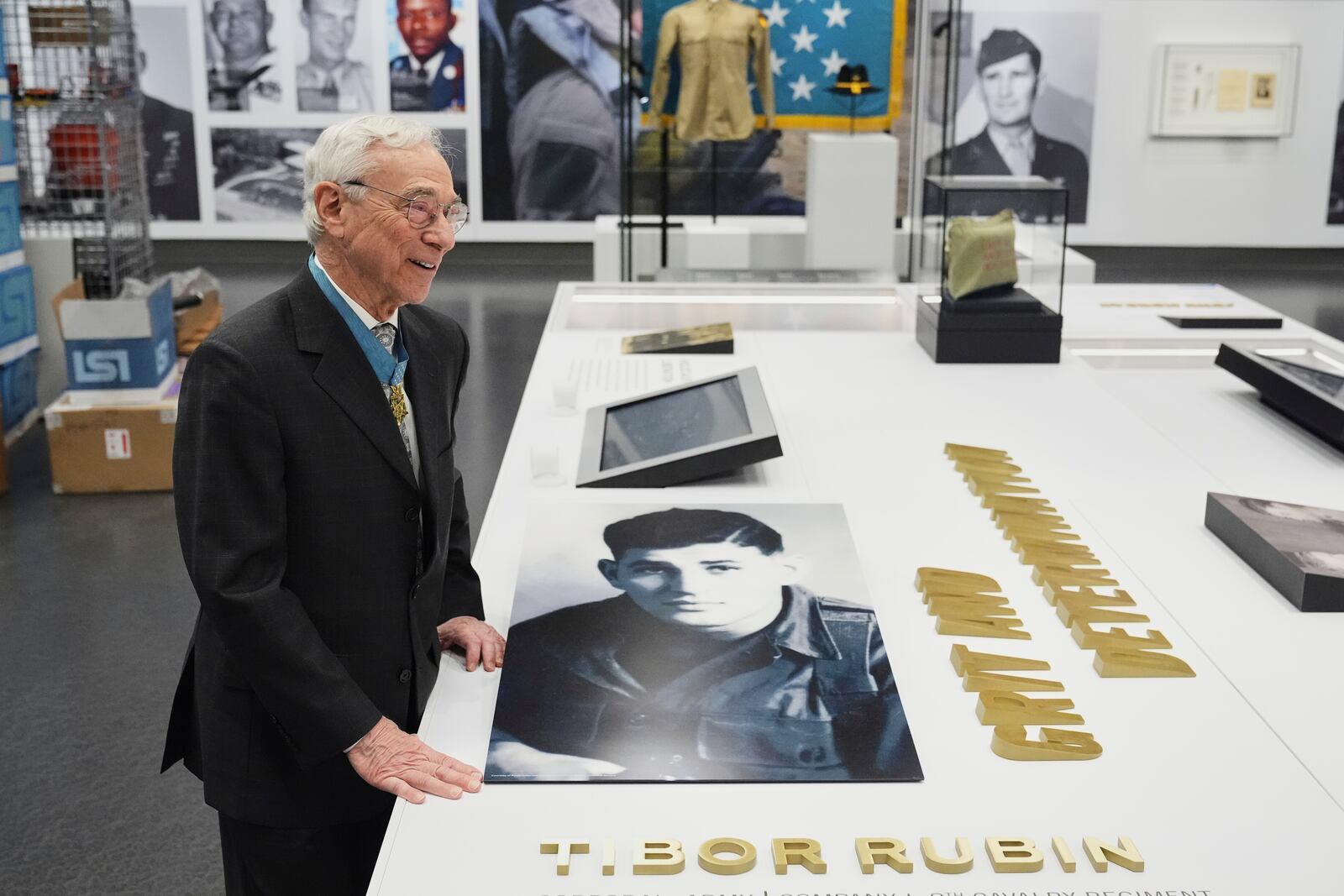 Jack Jacobs, a retired U.S. Army colonel who was awarded the Medal of Honor for his actions during the Vietnam War, responds to a question during an interview as he stands by an image of MOH recipient Tibor Rubin on display at the National Medal of Honor Museum in Arlington, Texas, Thursday, March 13, 2025. (AP Photo/Tony Gutierrez)