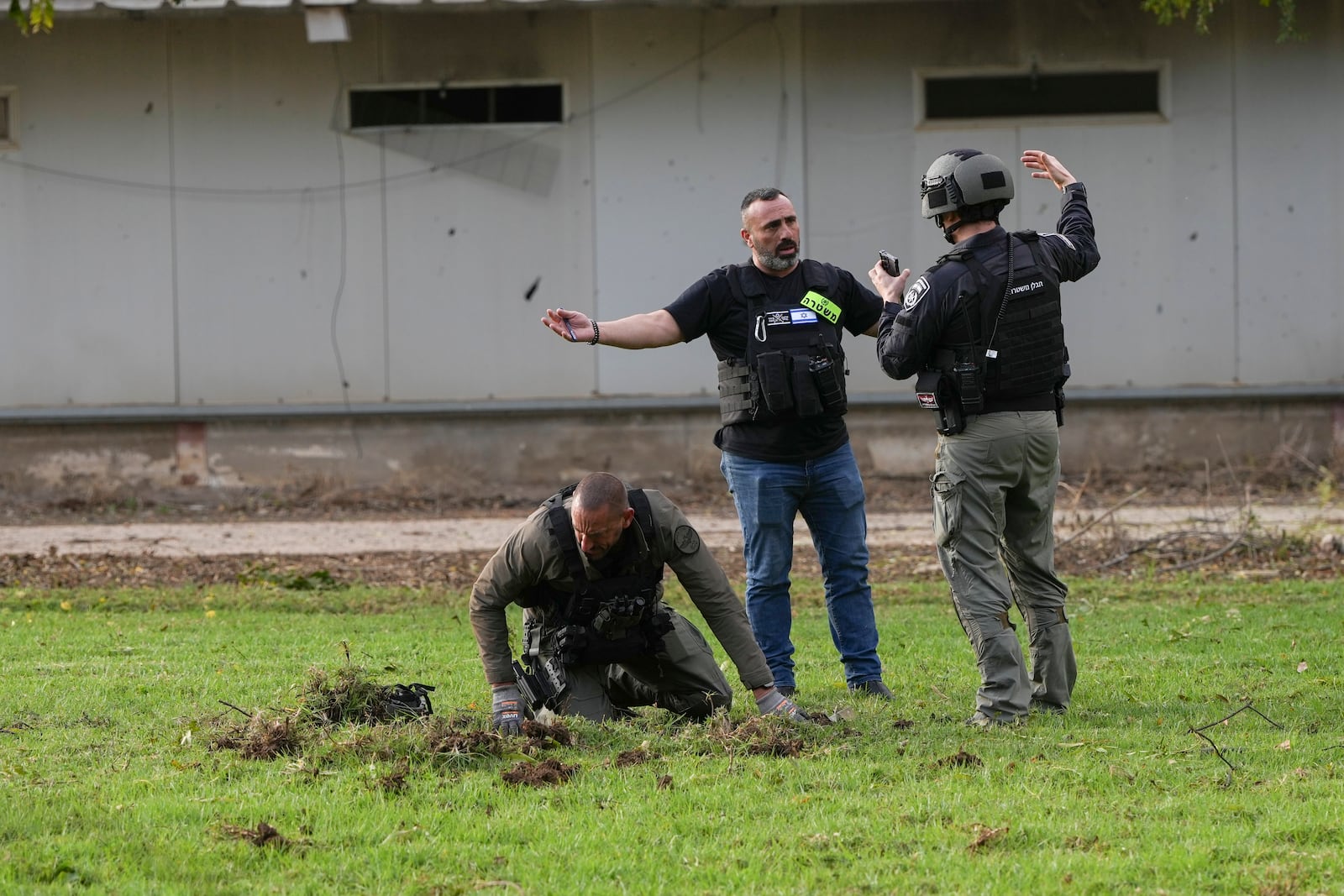 Israeli bomb squad police inspect the site where a rocket fired from Lebanon landed in Kibbutz Kfar Blum, northern Israel Sunday Nov. 24, 2024. (AP Photo/Ohad Zwigenberg)