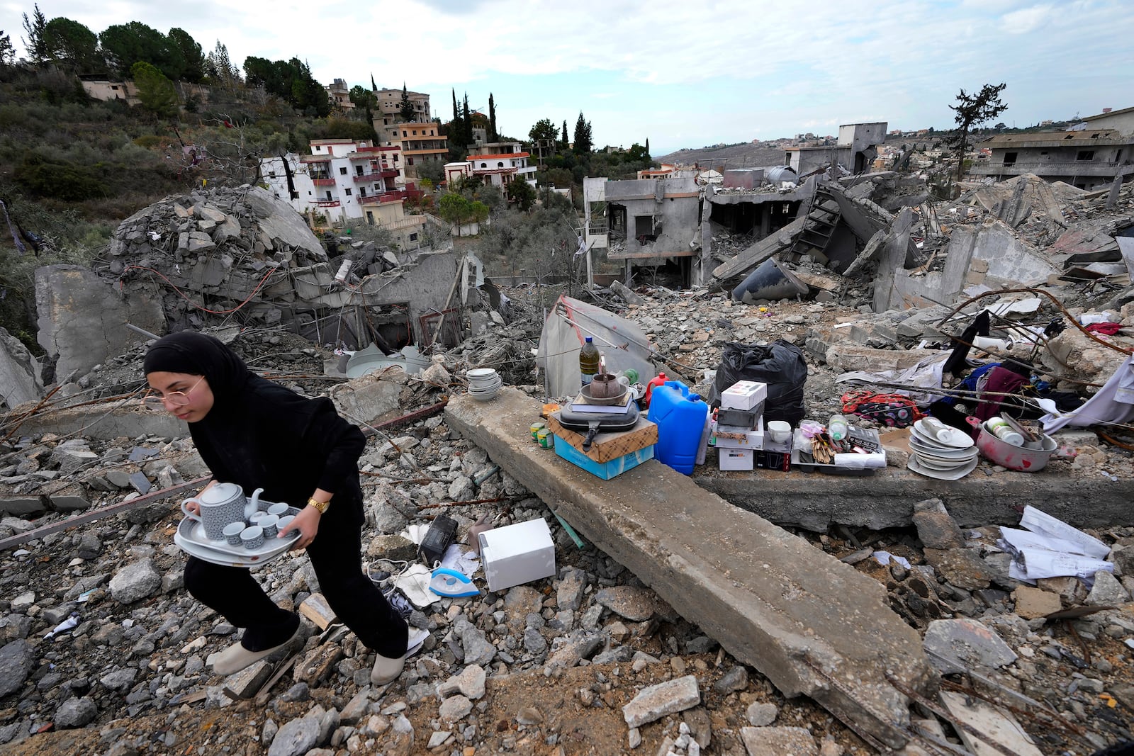 A woman collects the remains of her destroyed house after she returned to Chehabiyeh village, southern Lebanon, Thursday, Nov. 28, 2024 following a ceasefire between Israel and Hezbollah that went into effect on Wednesday.(AP Photo/Hussein Malla)