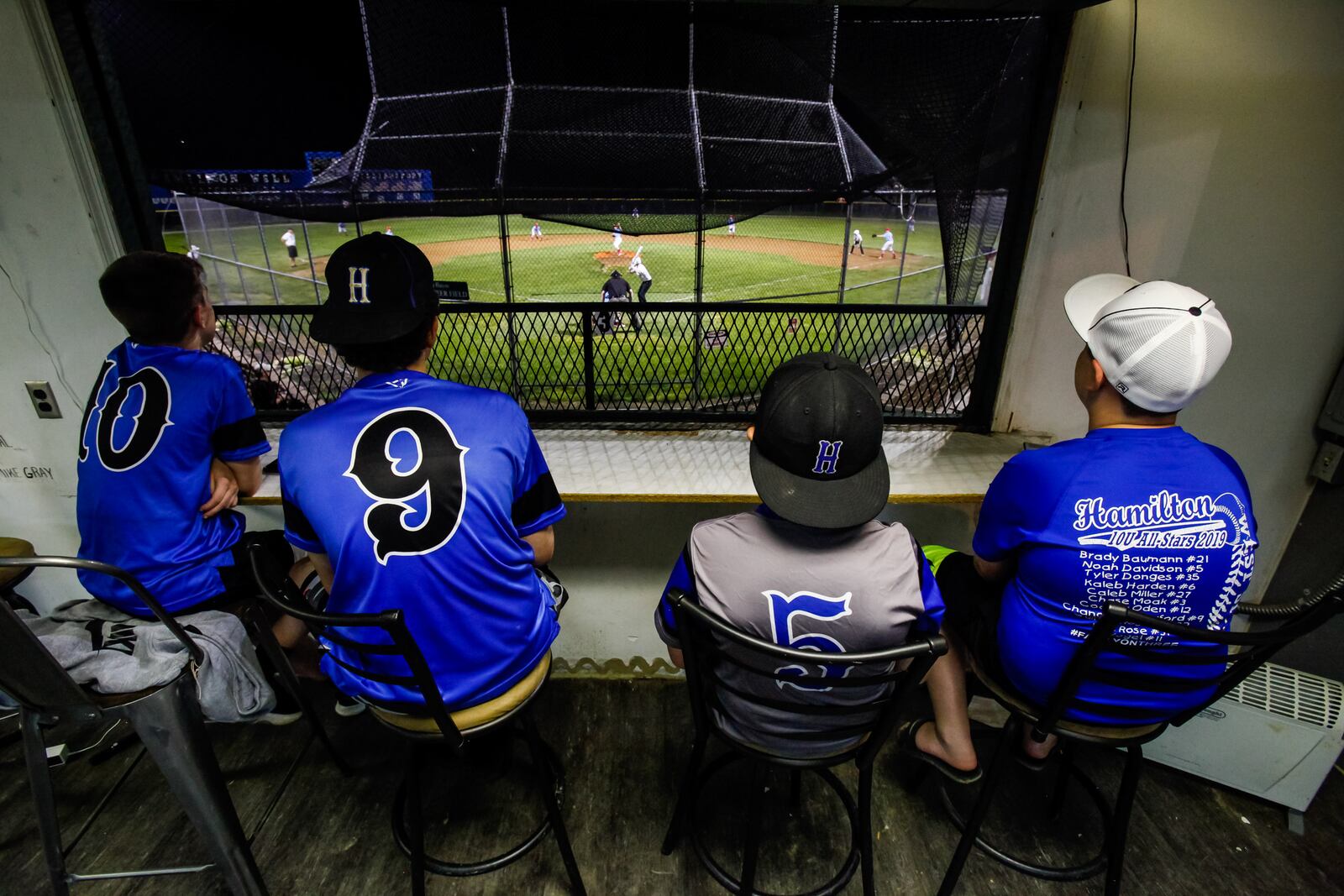 Hamilton West Side Little League players watch Dayton Impact and Storm Club teams from the press box as baseball action started up again just after midnight on Tuesday, May 26, 2020, at the West Side Little League fields. The press box is one of several structures that need to be repaired or replaced. West Side Little League is embarking on a $1 million capital campaign to upgrade the decades-old facility. NICK GRAHAM/FILE