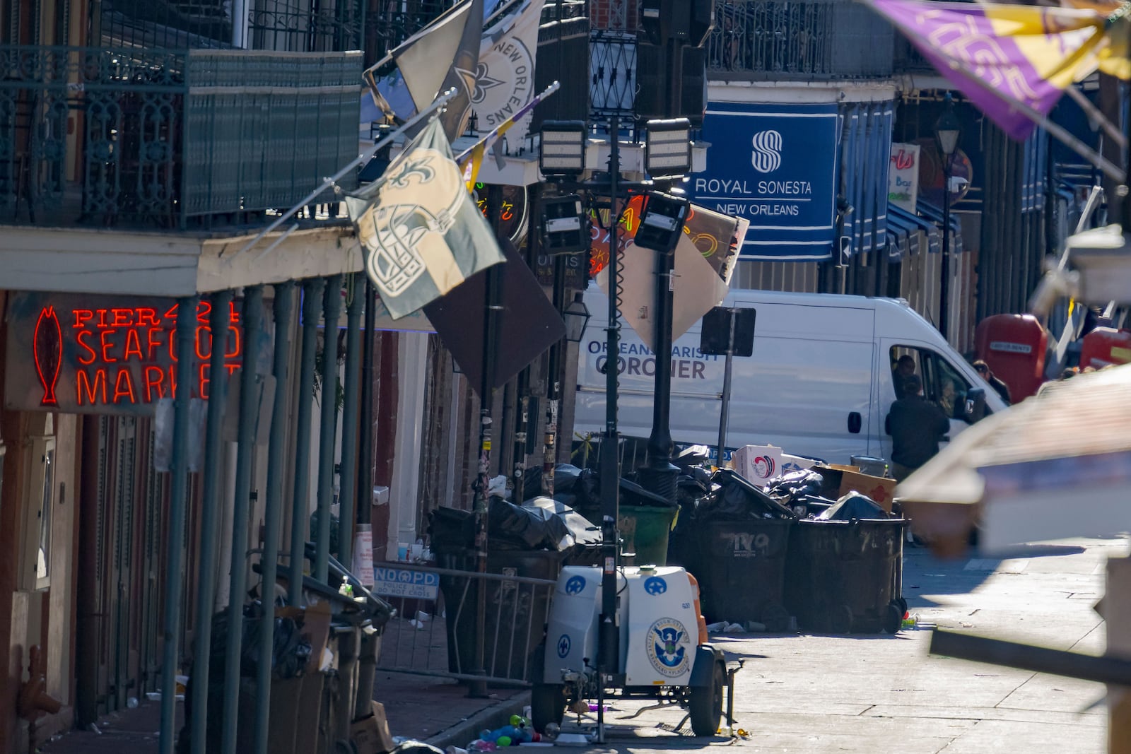 An Orleans Parish Coroner van is seen on Bourbon Street during the investigation of a pickup truck crashing into pedestrians on Bourbon Street in front of the Royal Sonesta Hotel in the French Quarter in New Orleans, Wednesday, Jan. 1, 2025. (AP Photo/Matthew Hinton)