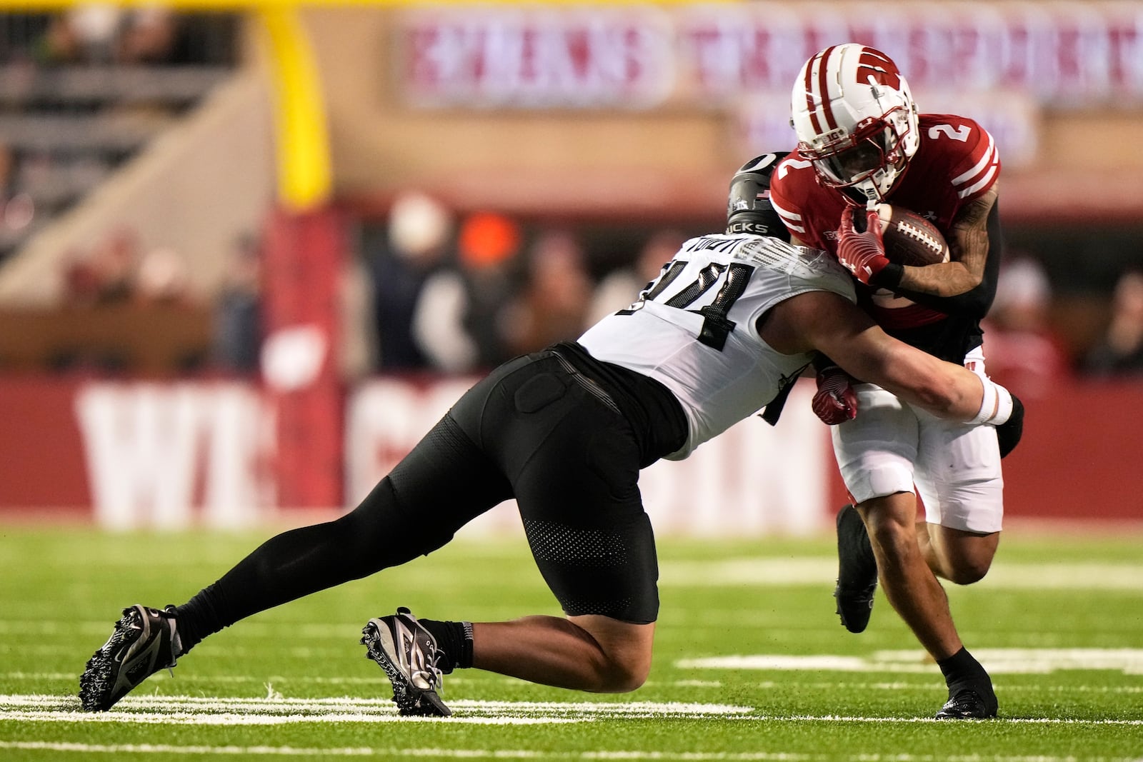 Wisconsin's Trech Kekahuna (2) is styopped by Oregon's Teitum Tuioti (44) during the first half of an NCAA college football game Saturday, Nov. 16, 2024, in Madison, Wis. (AP Photo/Morry Gash)