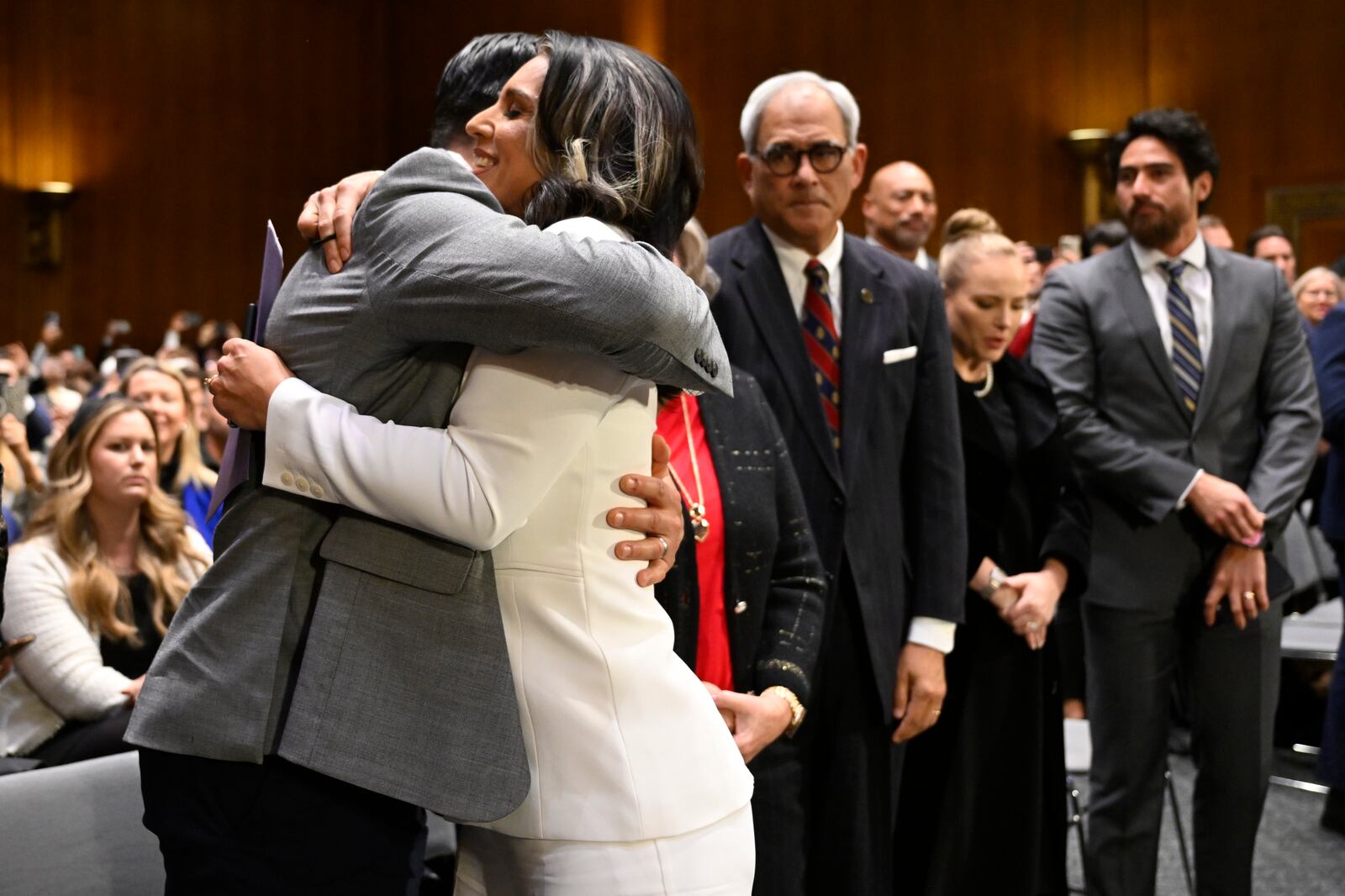 Former Rep. Tulsi Gabbard, President Donald Trump's choice to be the Director of National Intelligence, right, is greeted by friends after her appearance before the Senate Intelligence Committee for her confirmation hearing at the U.S. Capitol, Thursday, Jan. 30, 2025, in Washington. (AP Photo/John McDonnell)