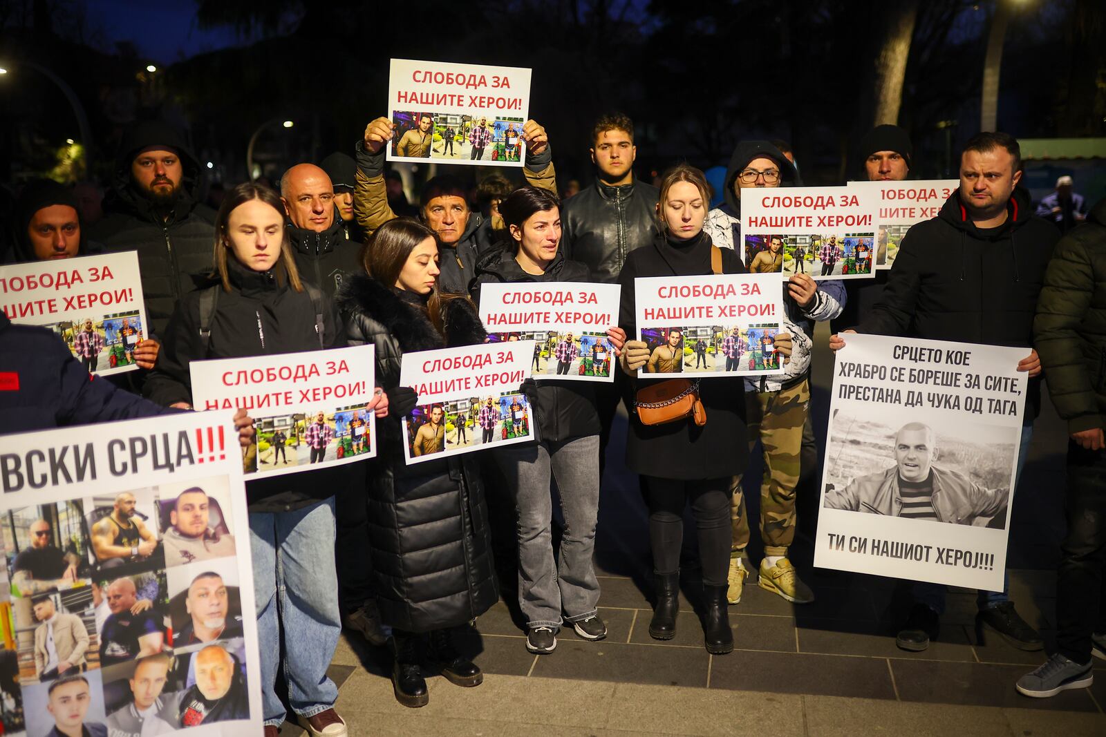 People hold posters of security personnel of a nightclub that was the scene of a massive fire, which read "Freedom for Our Heroes" in the town of Kocani, North Macedonia, Tuesday, March 18, 2025. (AP Photo/Armin Durgut)