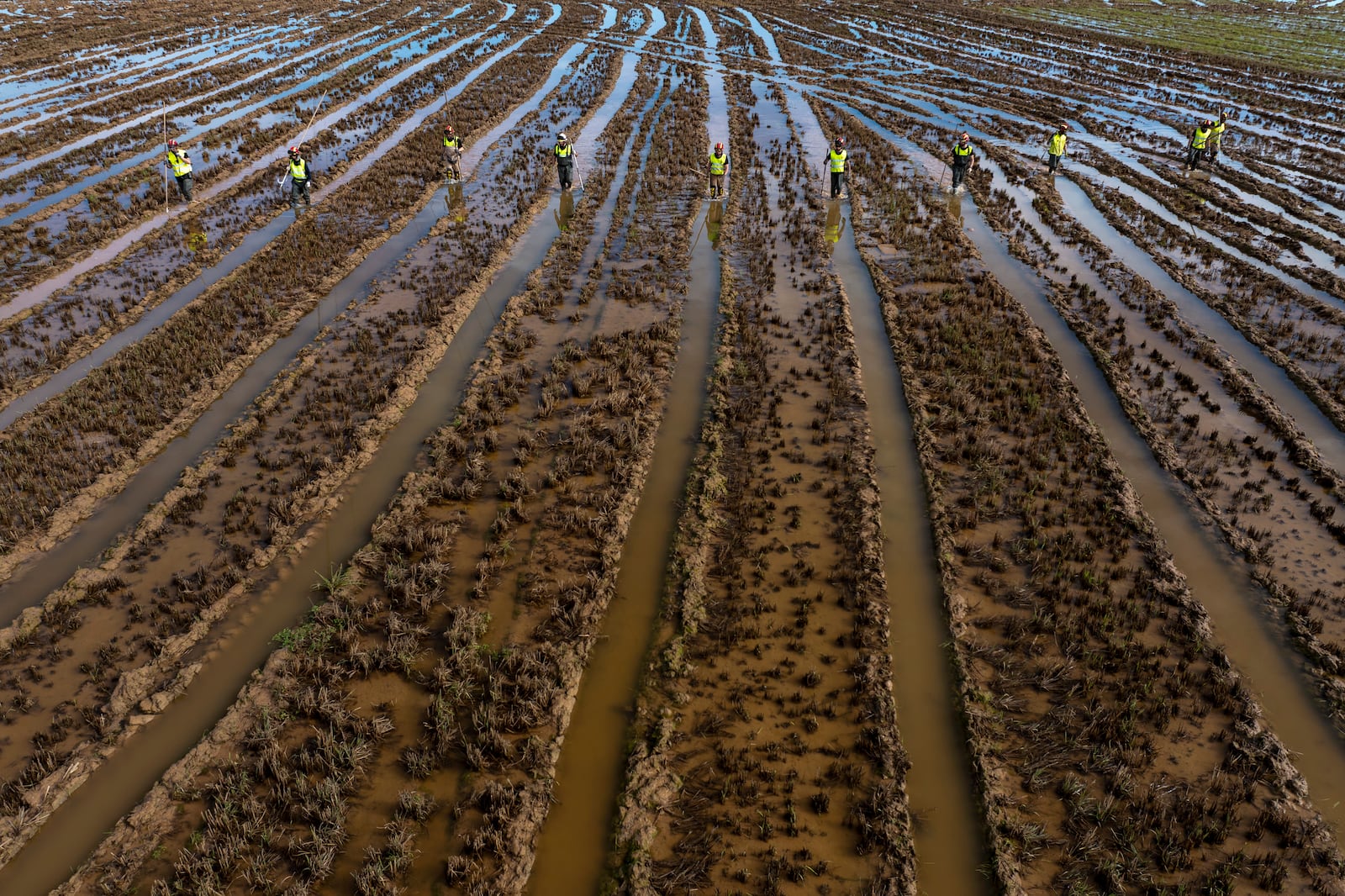 Members of the V battalion of the military emergency unit, UME, search the area for bodies washed away by the floods in the outskirts of Valencia, Spain, Friday, Nov. 8, 2024. (AP Photo/Emilio Morenatti)